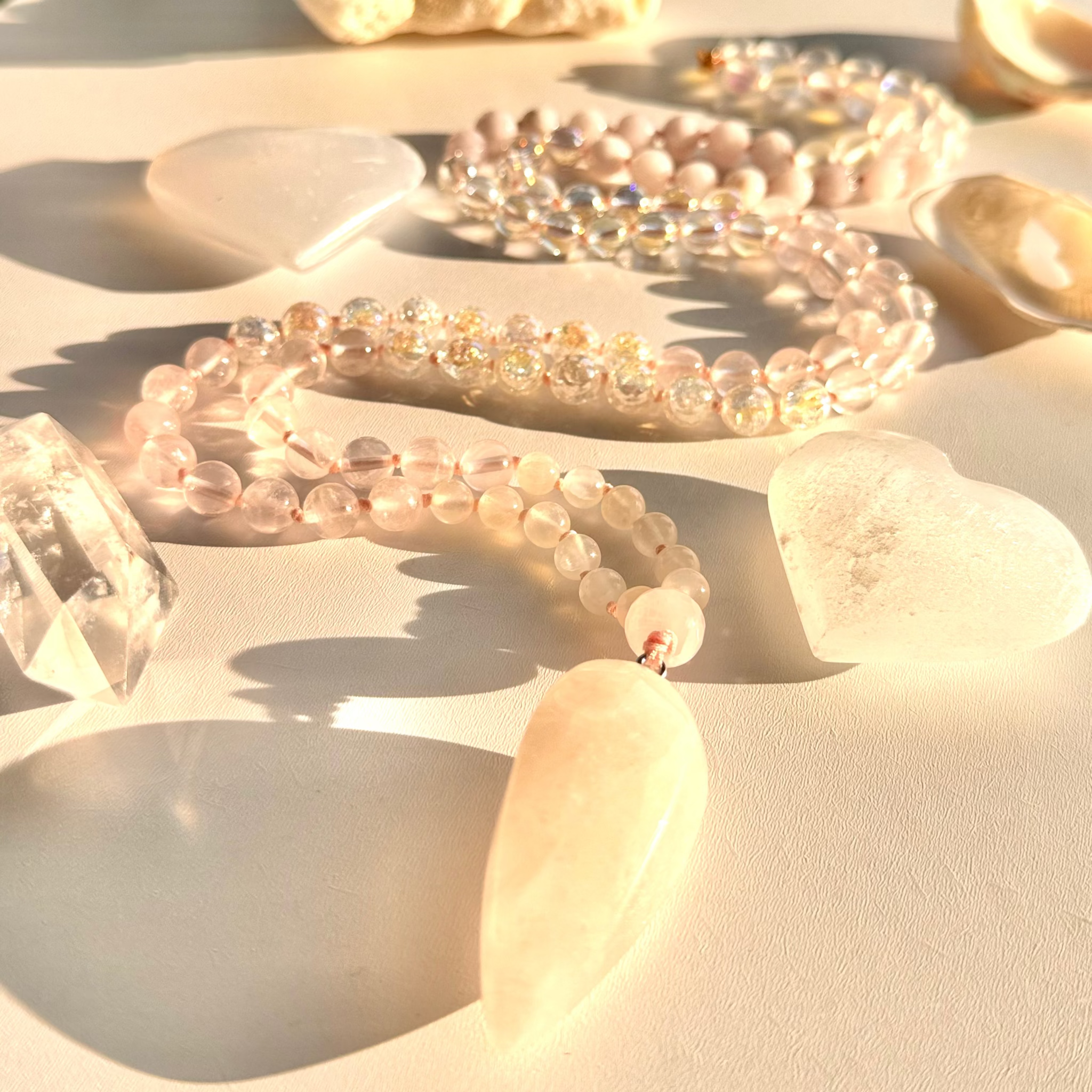 Clear Bead necklaces on a sandy surface with seashells