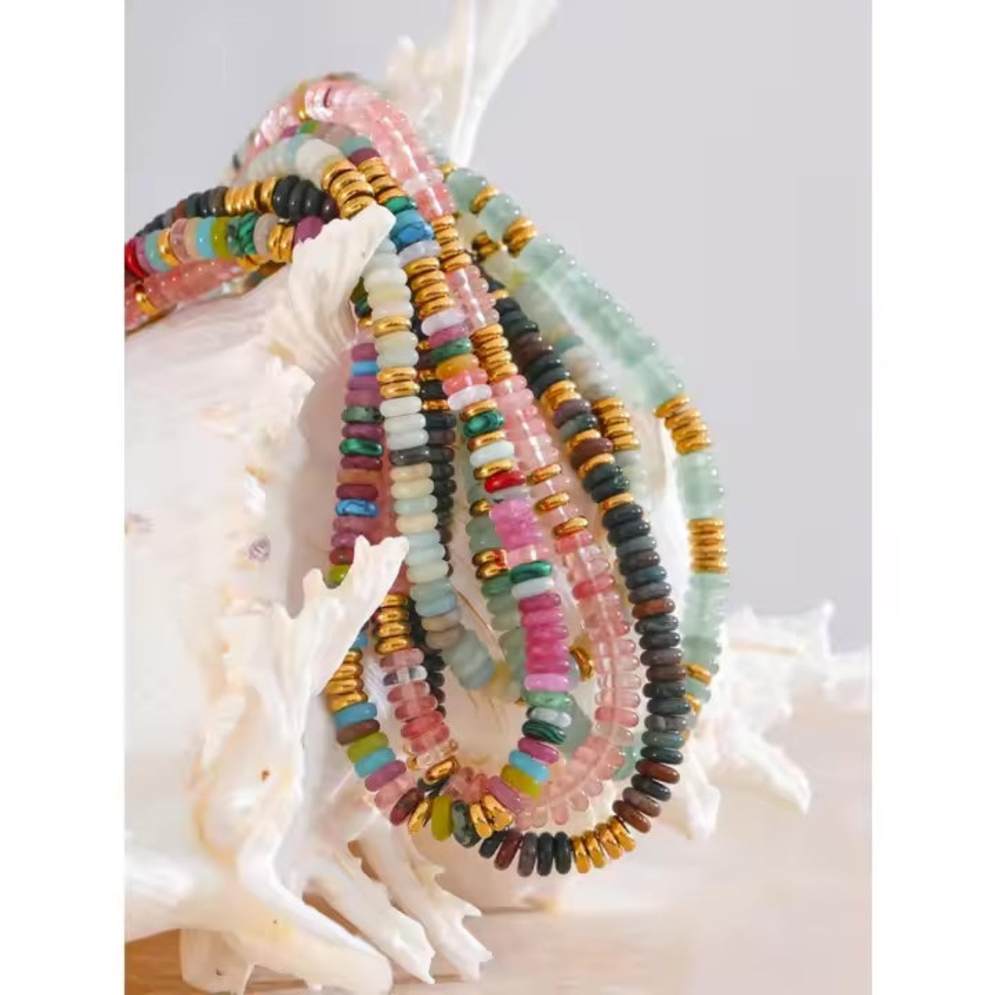 Colorful beaded bracelets on a white shell with a light gray background