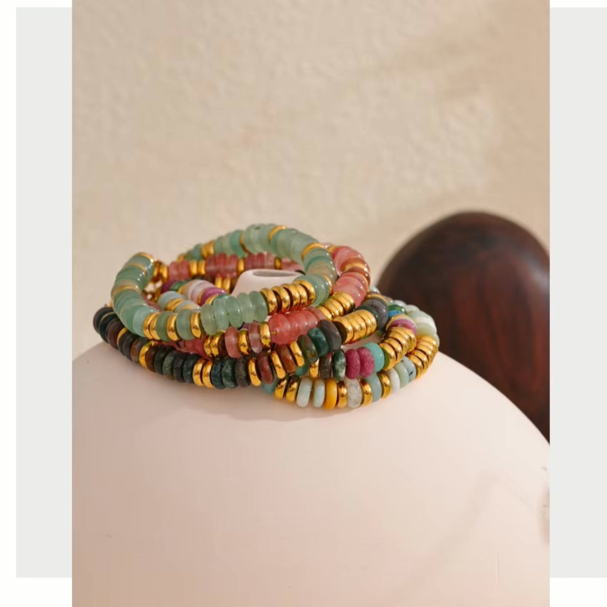 Set of colorful beaded bracelets on a beige surface