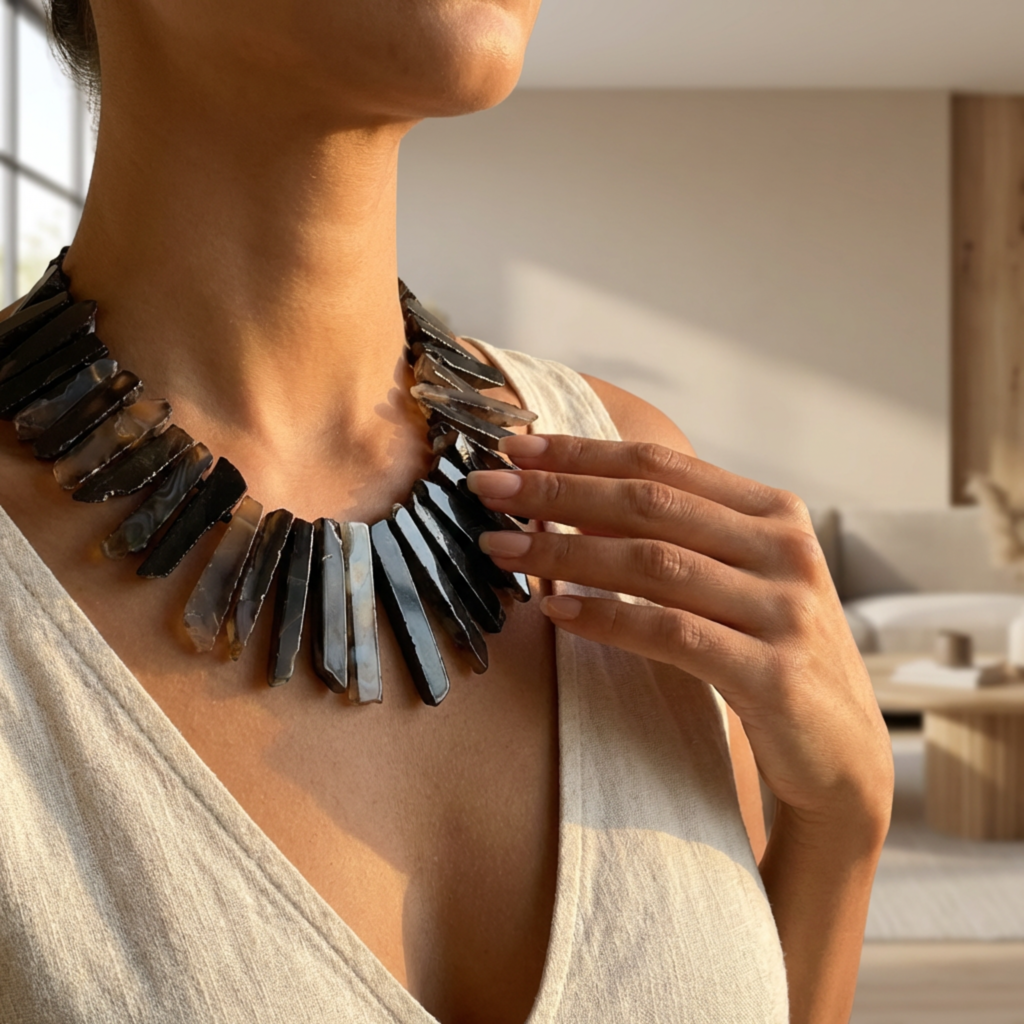 Person wearing a large, dark metallic necklace in an indoor setting