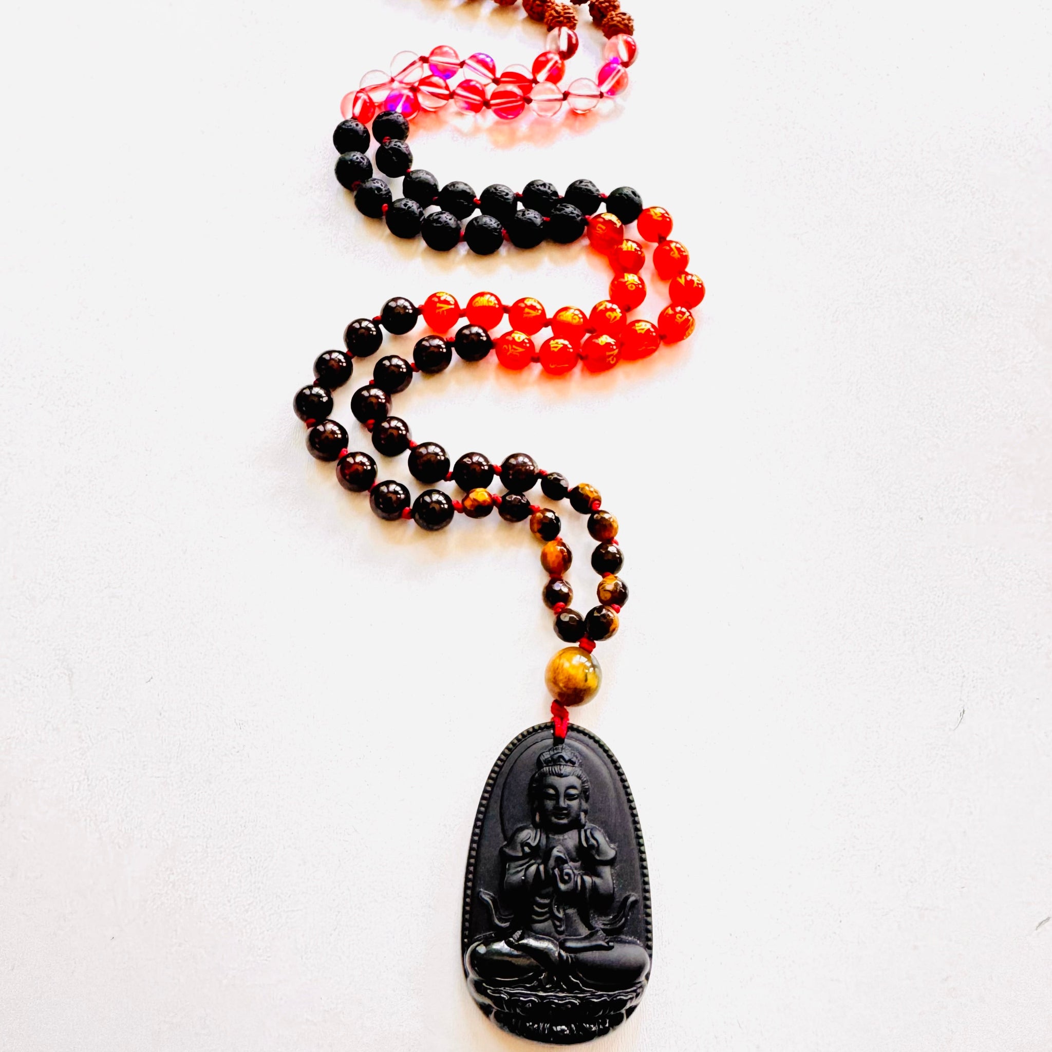 Mala beads with a Buddha pendant on a white background