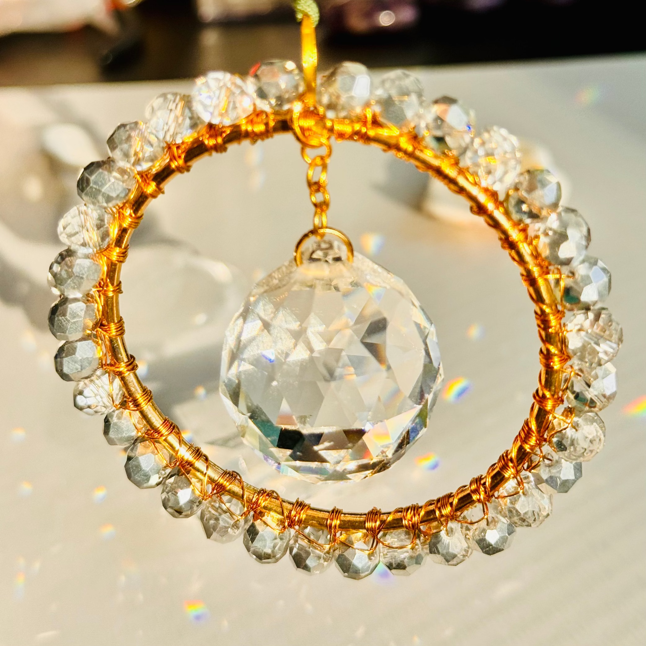 Crystal ball with gold and clear bead frame on a reflective surface