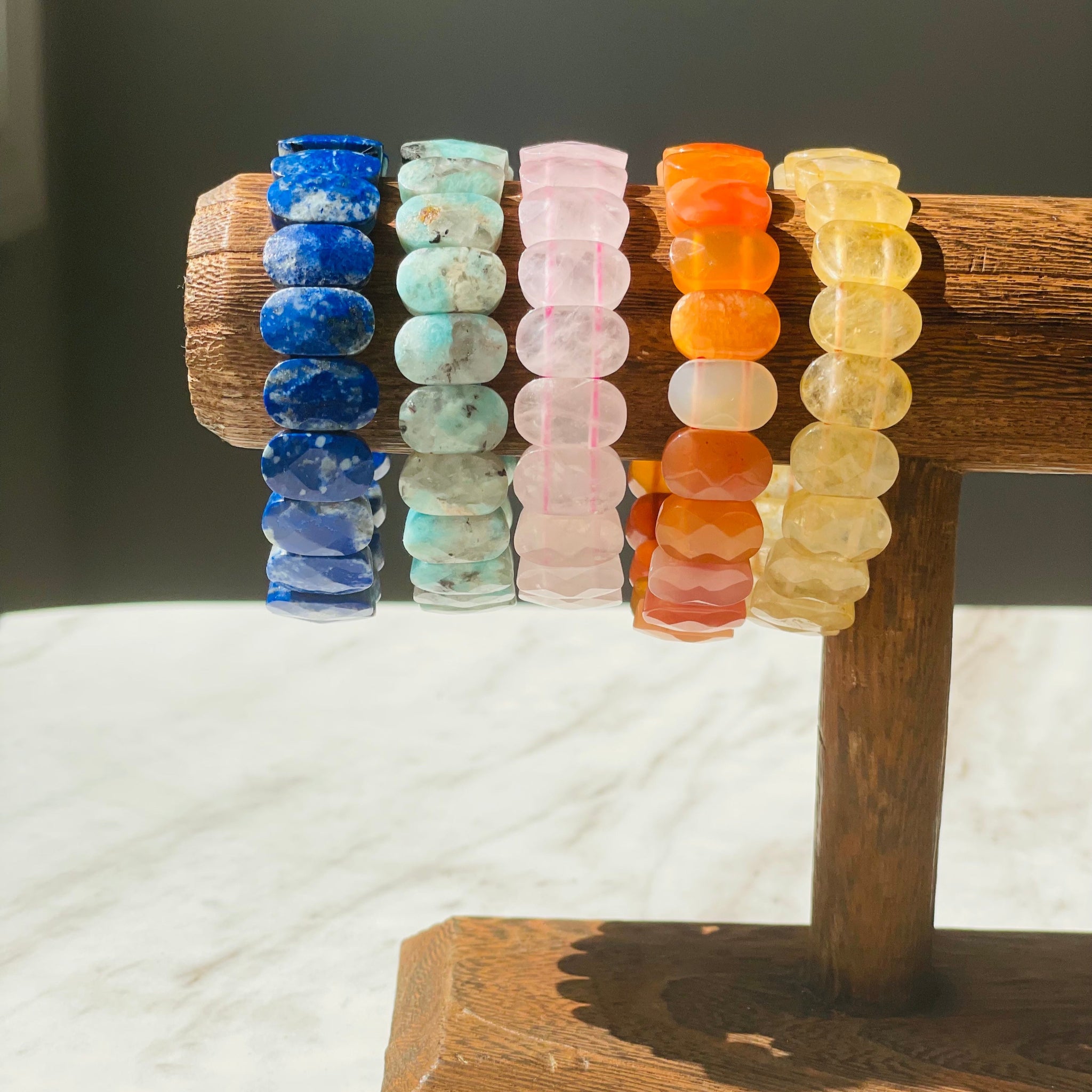 colorful gemstone bracelets on wooden display