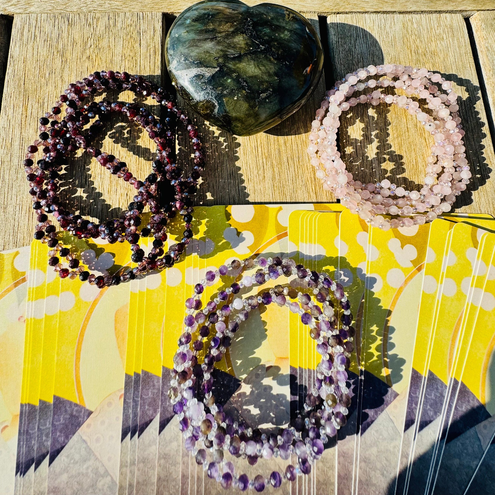 Assorted colorful Tantric necklaces on wood surface