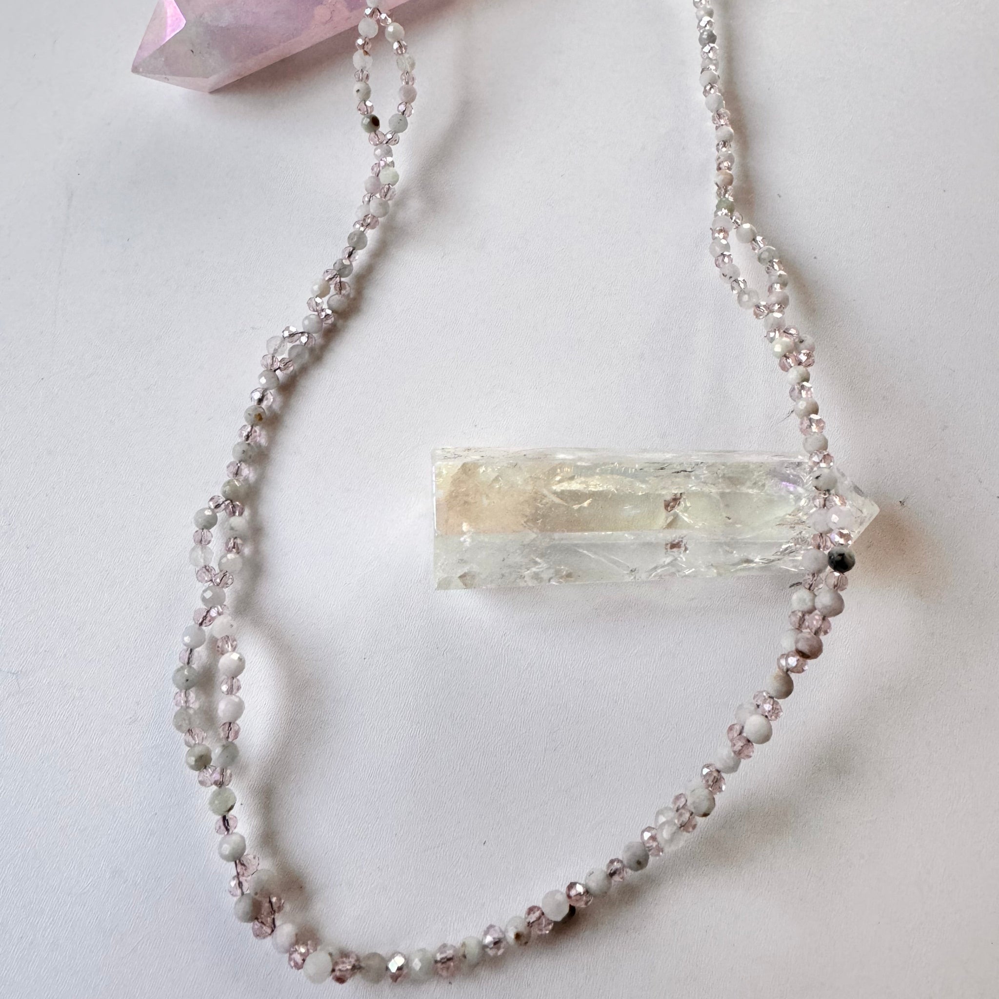 Kunzite Tantric Necklace on white surface and white crystal