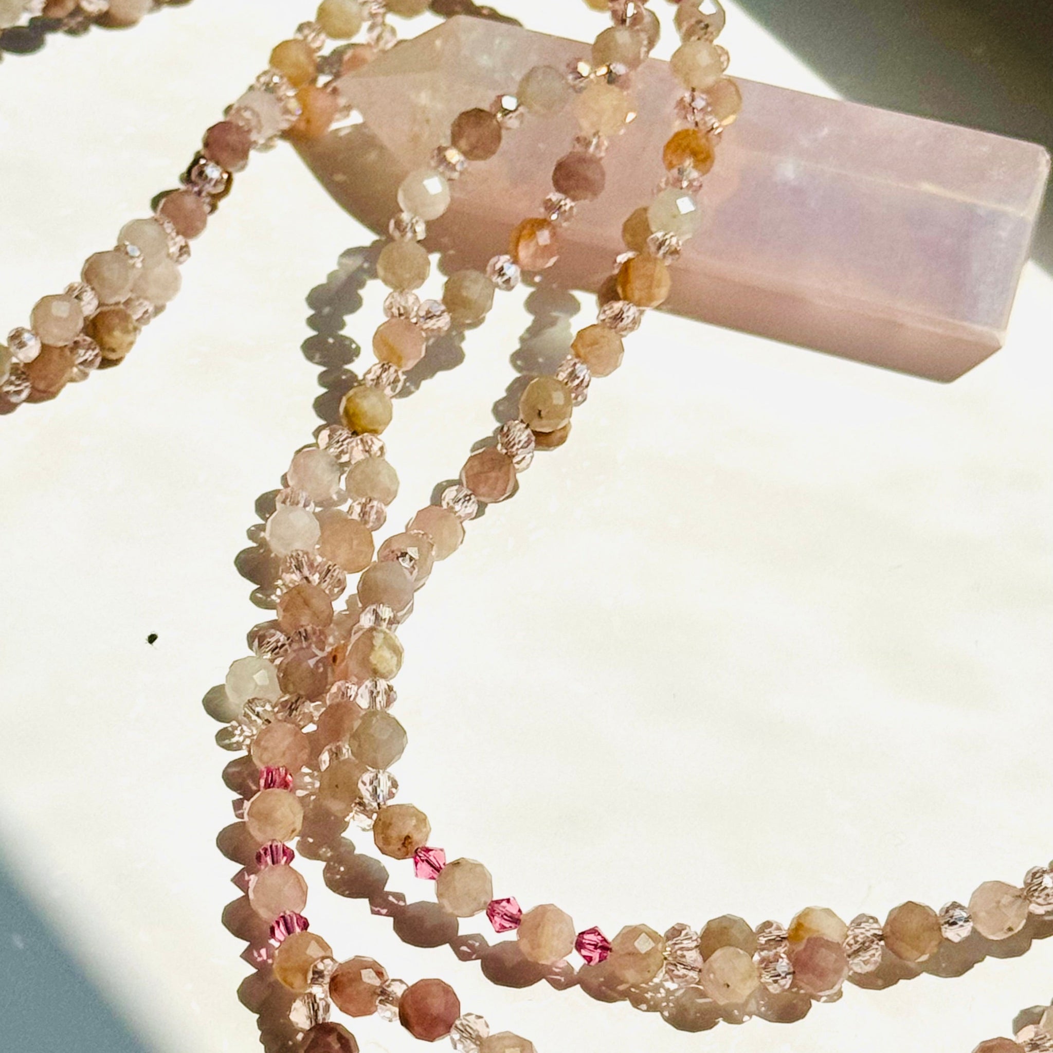 pink and neutral pink beaded necklace closeup photo on white surface