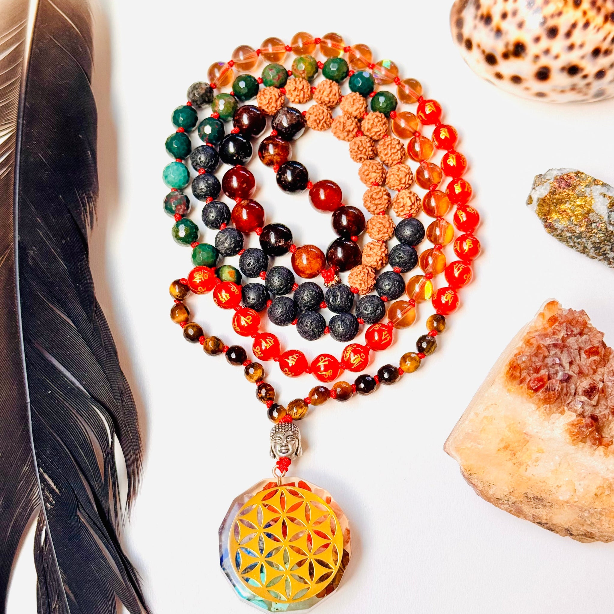Colorful beaded necklace with a yellow pendant on a white surface with a feather and shell.