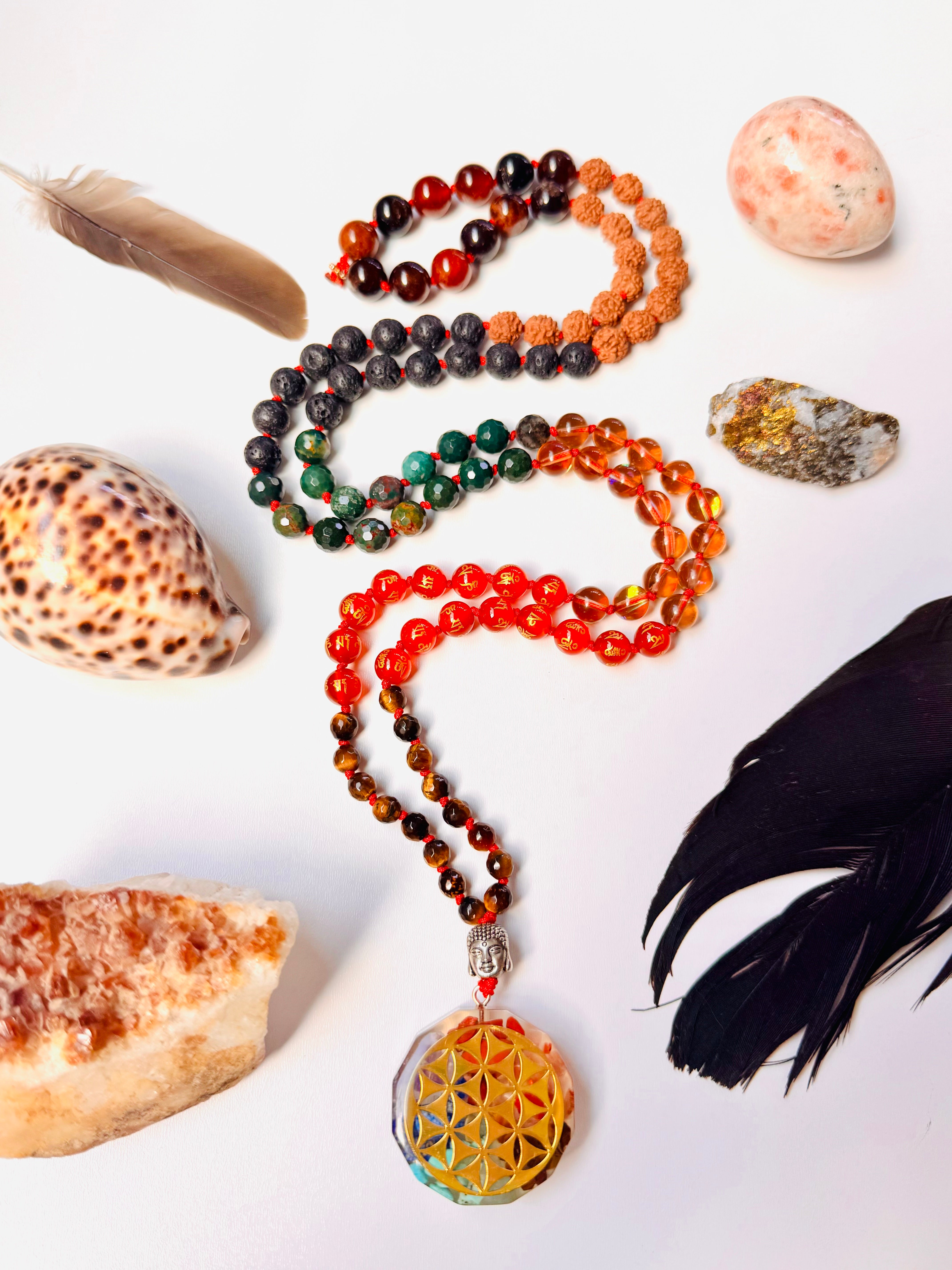 Colorful beaded necklace with a pendant on a white background with shells and feathers.