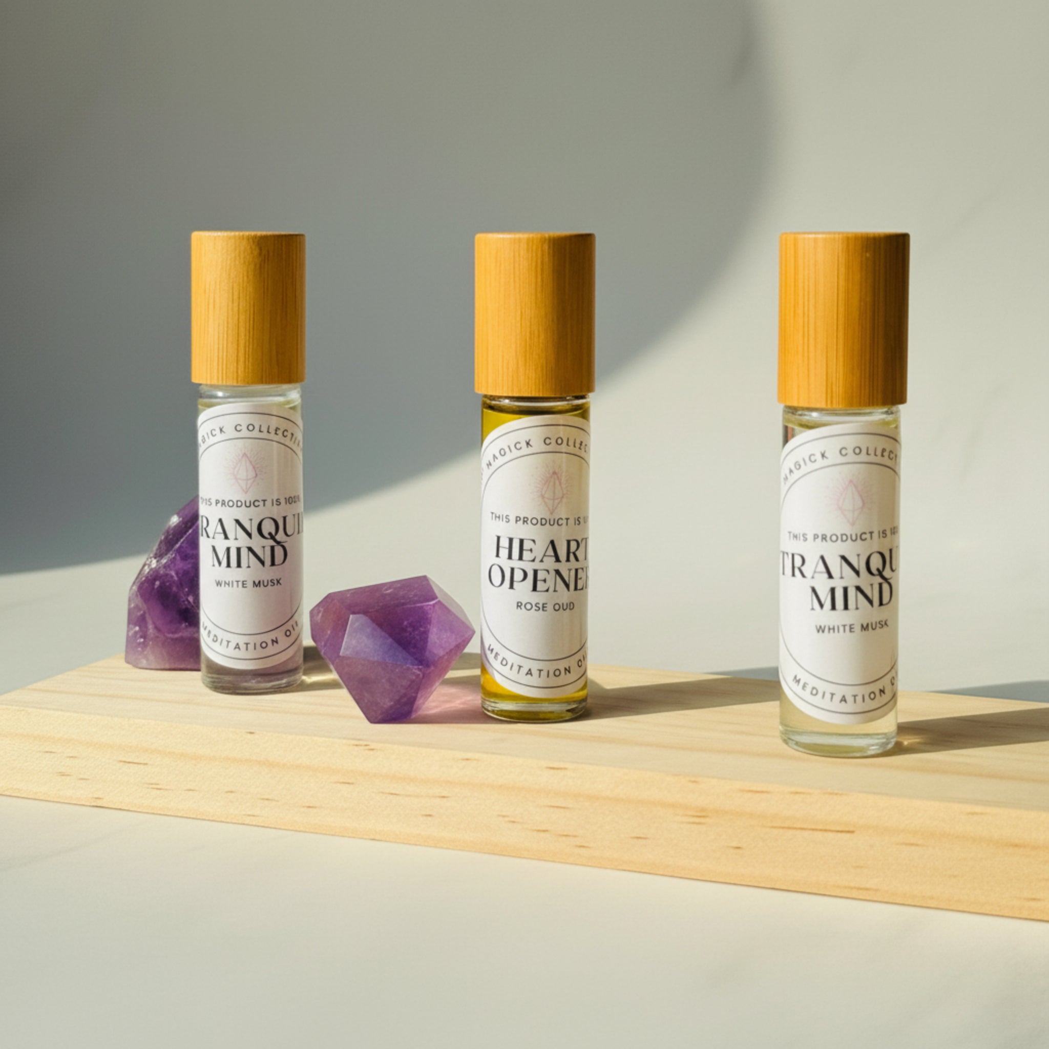 Heart Opener Oil and Tranquil Mind Oils on wooden surface with Amethyst