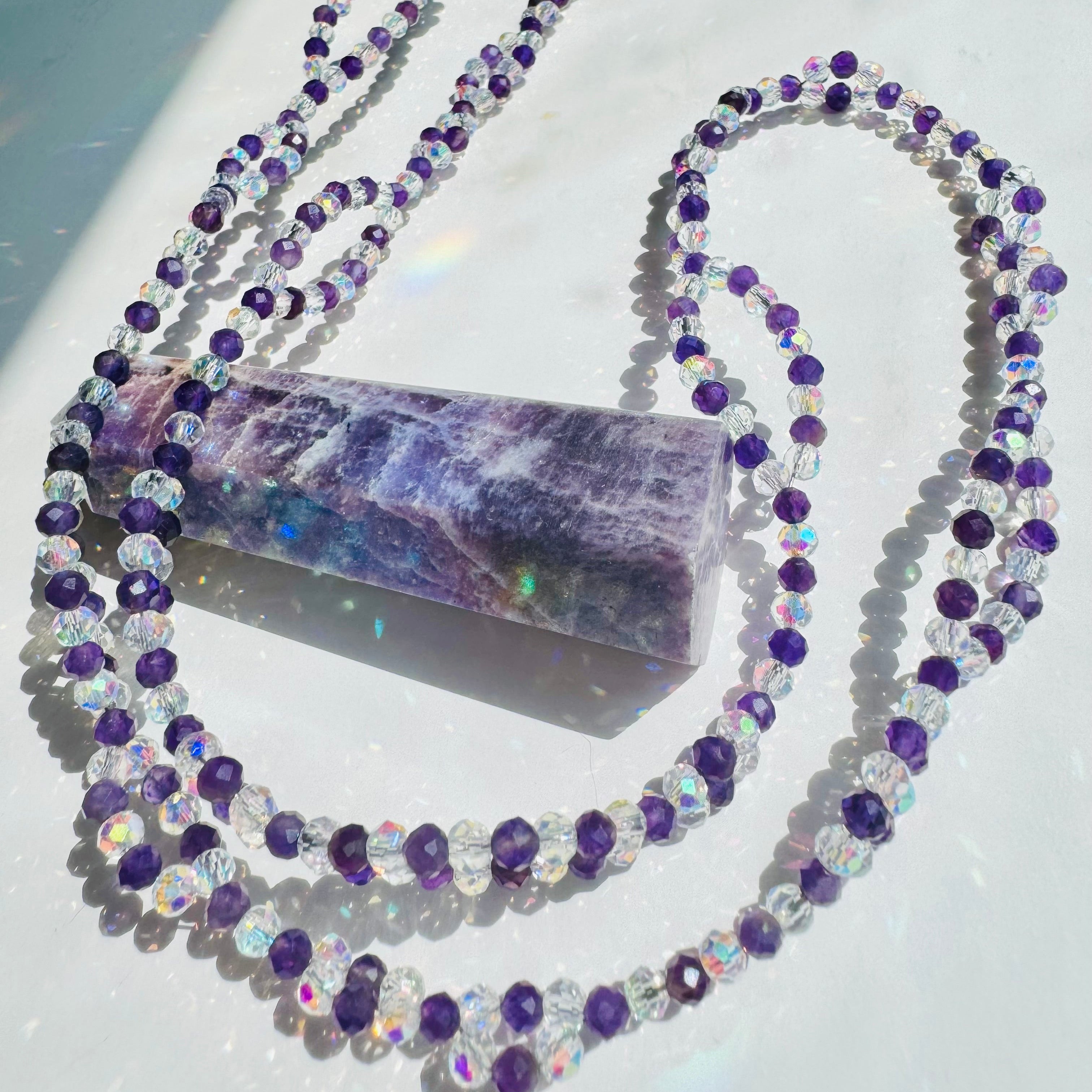 Inner Peace Amethyst Tantric Necklace
on white surface closeup photo on decorative purple crystal