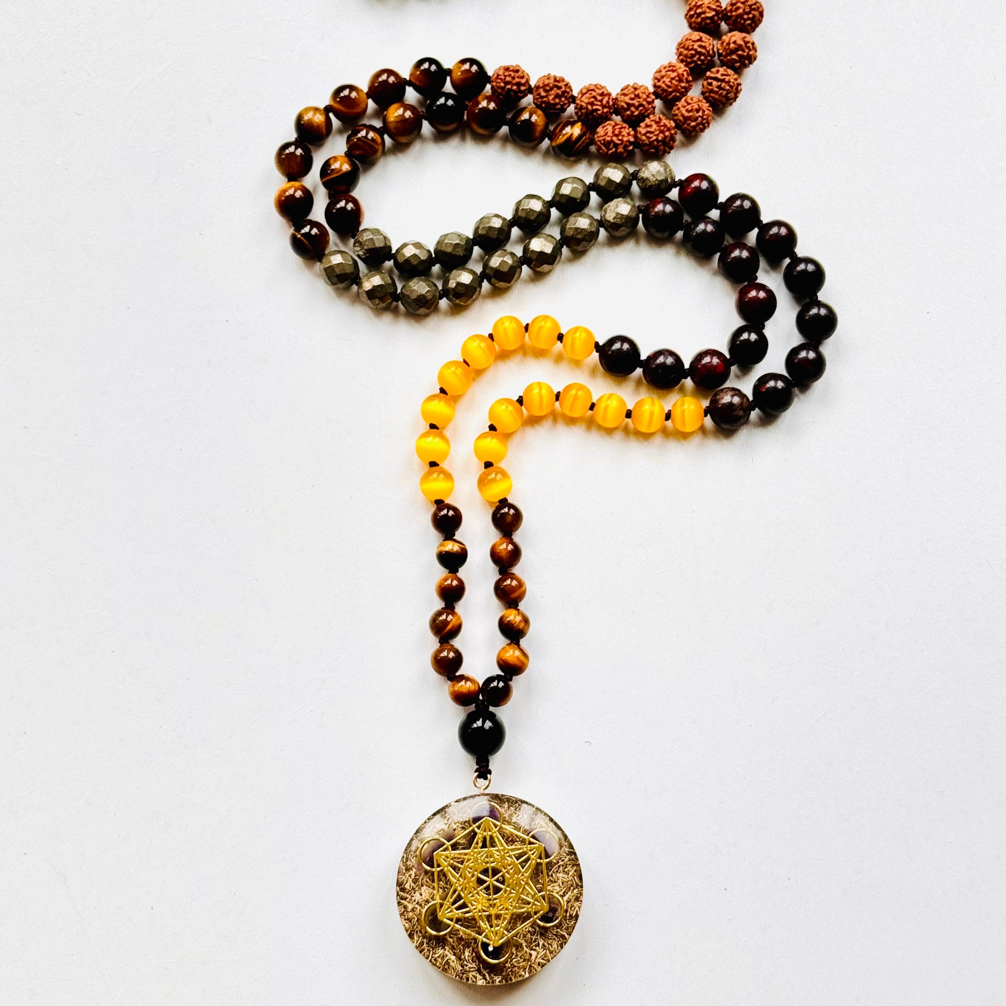 A beaded mala necklace with a Metatron's Cube pendant, featuring various colored beads and a gold-colored pendant.