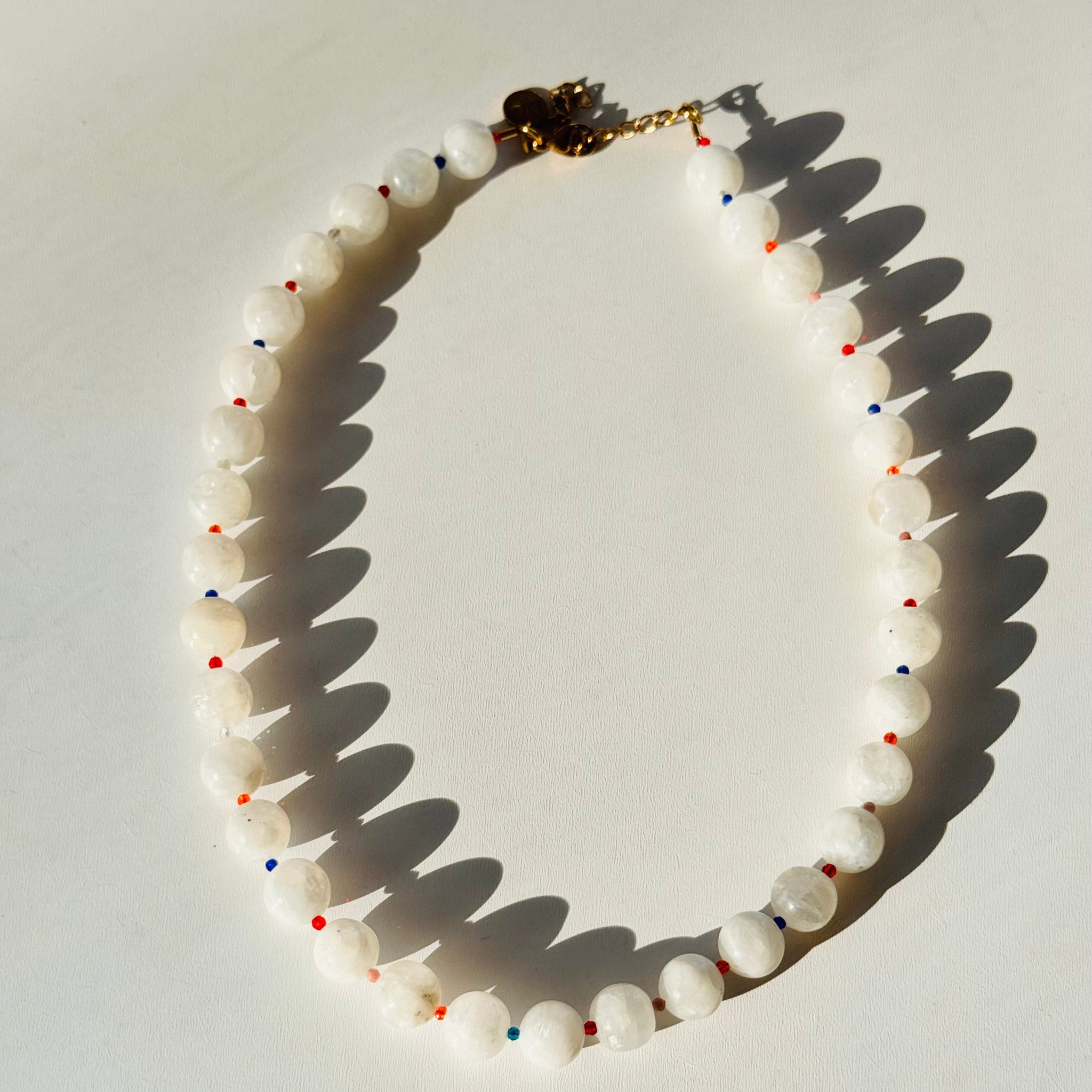 Necklace with white beads and colorful accents on a light background