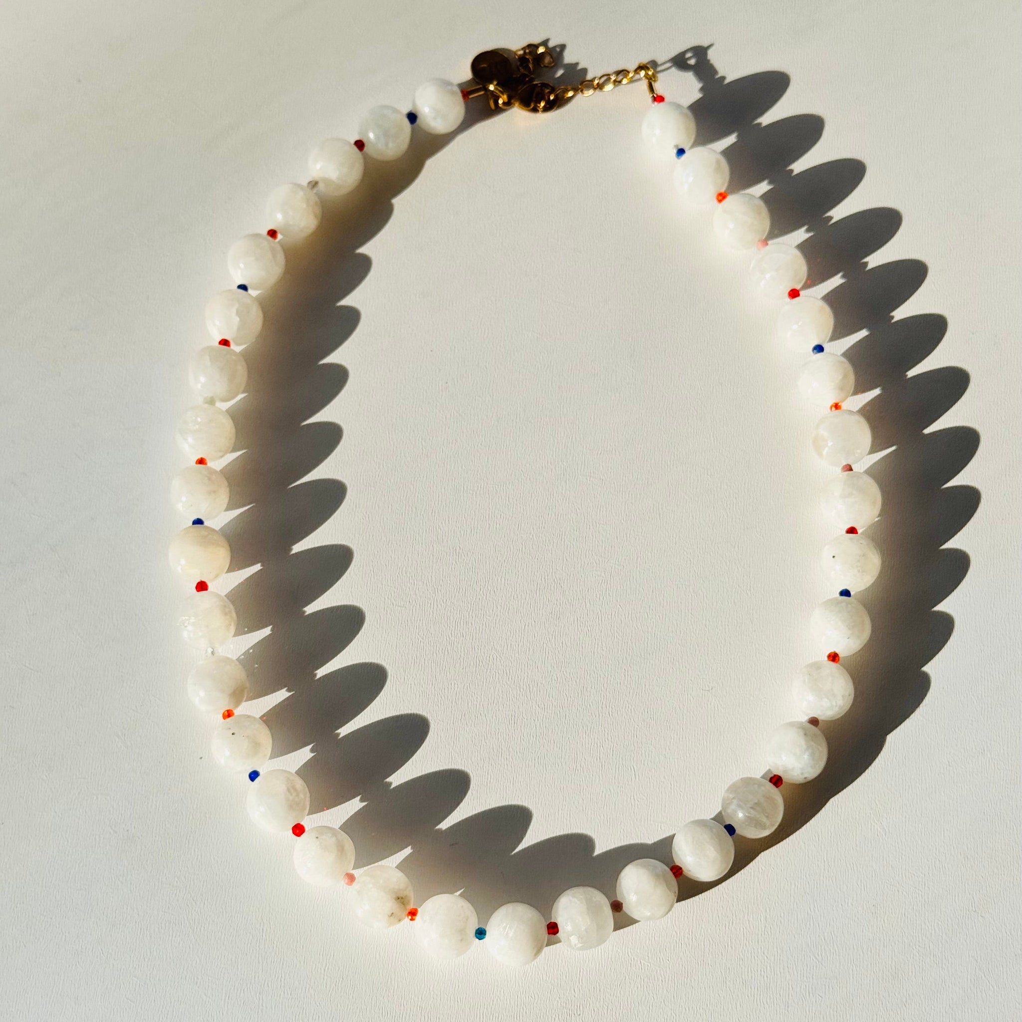 Necklace with white beads and colorful accents on a light background