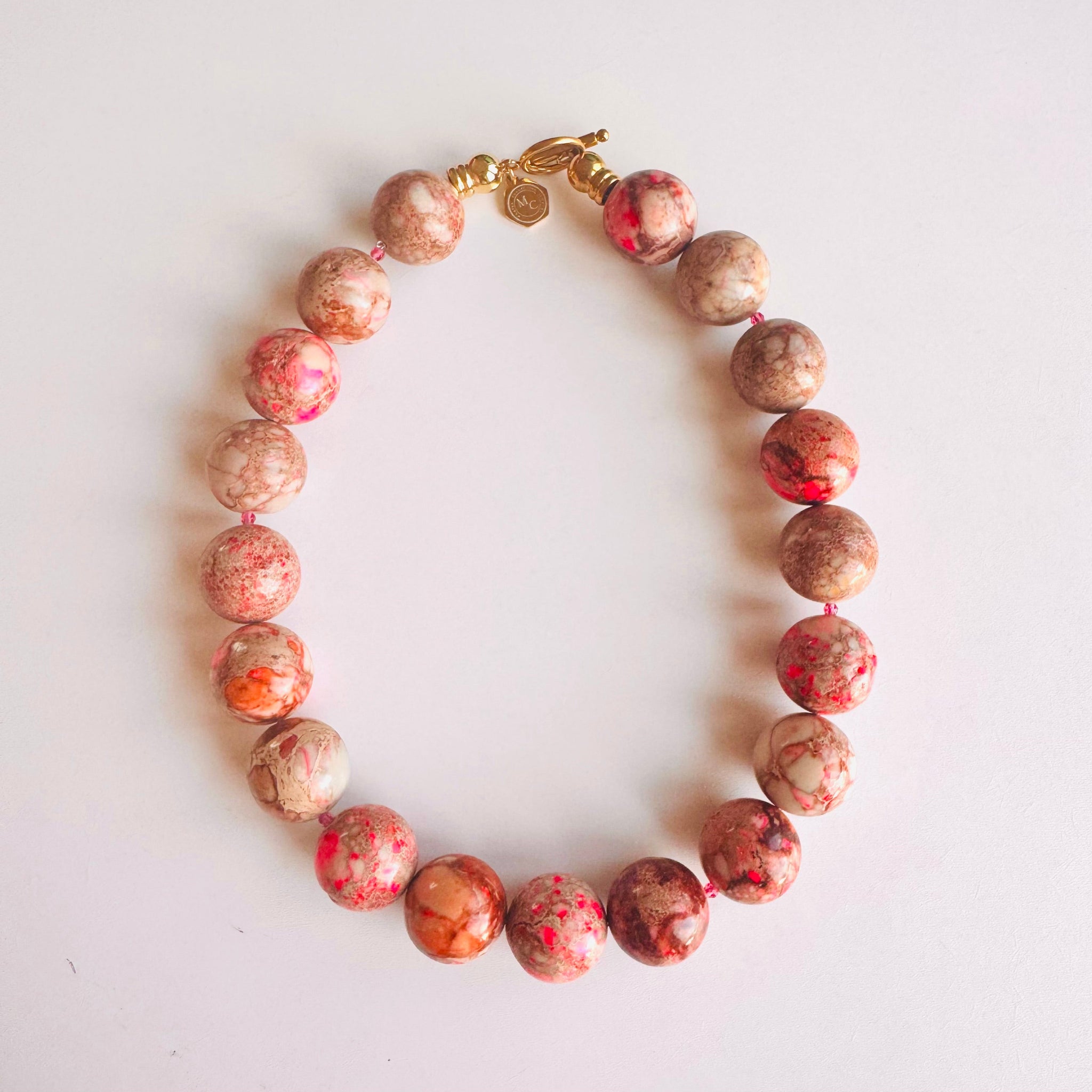 Necklace with pink and brown beads on a white background