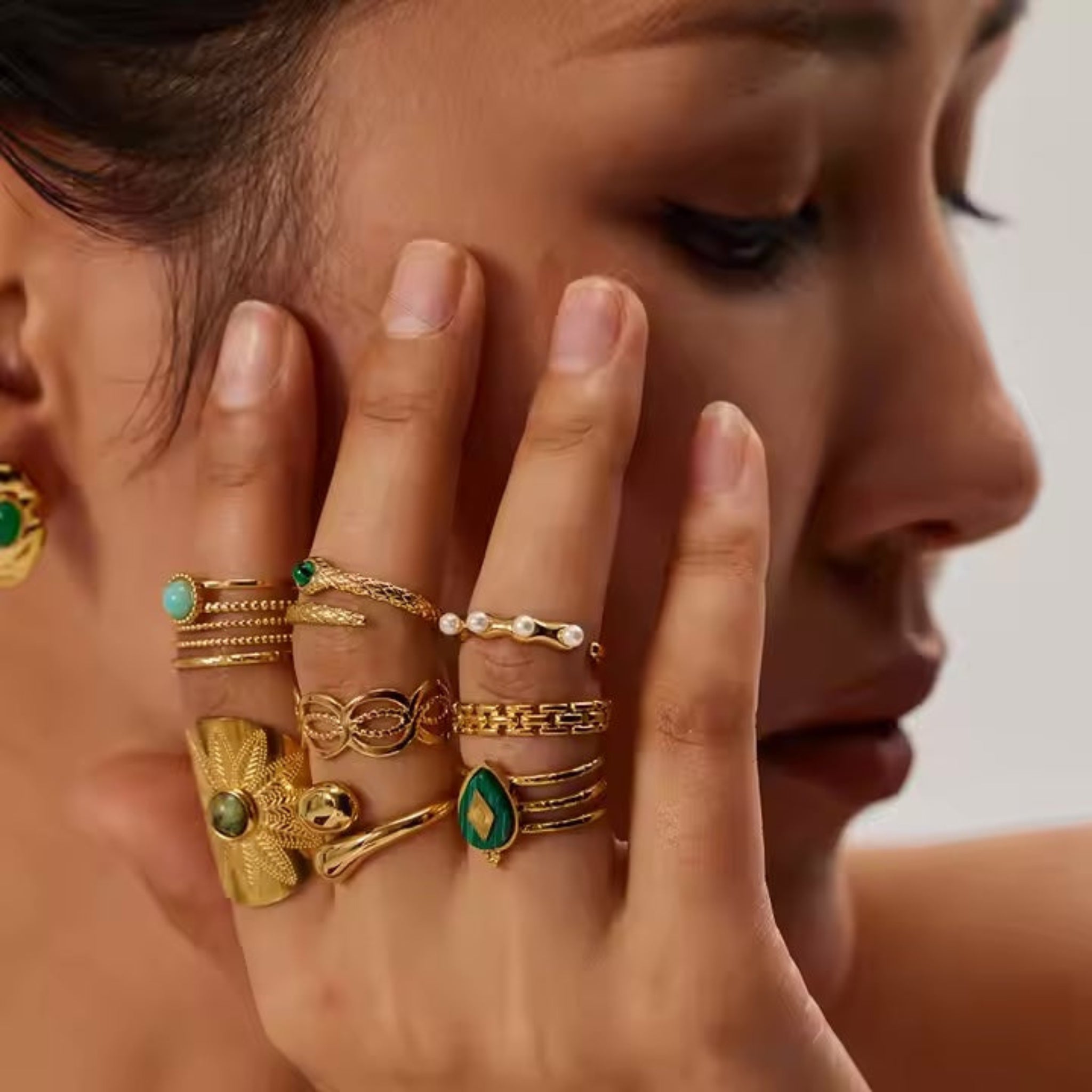 assorted rings on model hand posing at her cheek