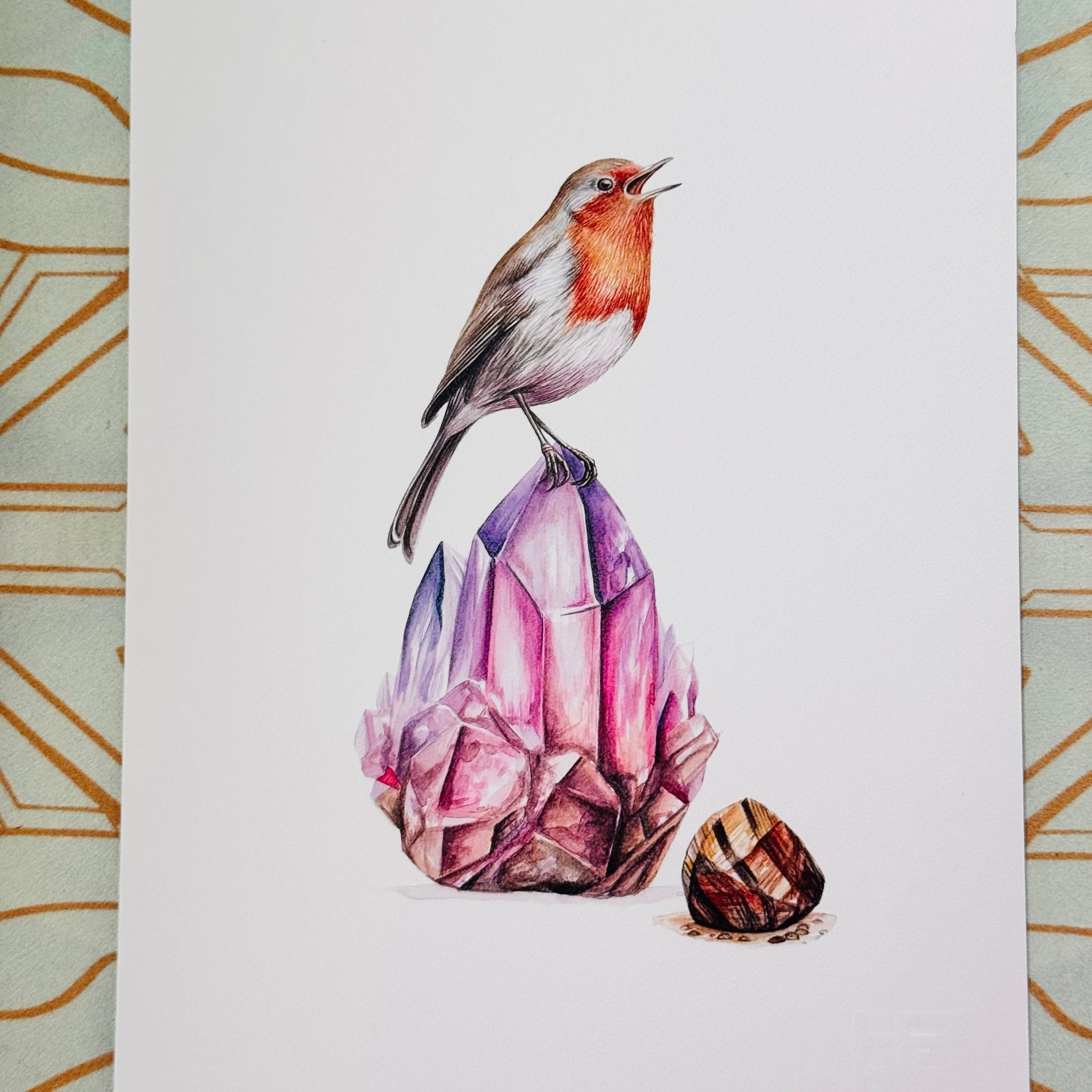 Illustration of a robin on a pink crystal with a gold geometric pattern in the background