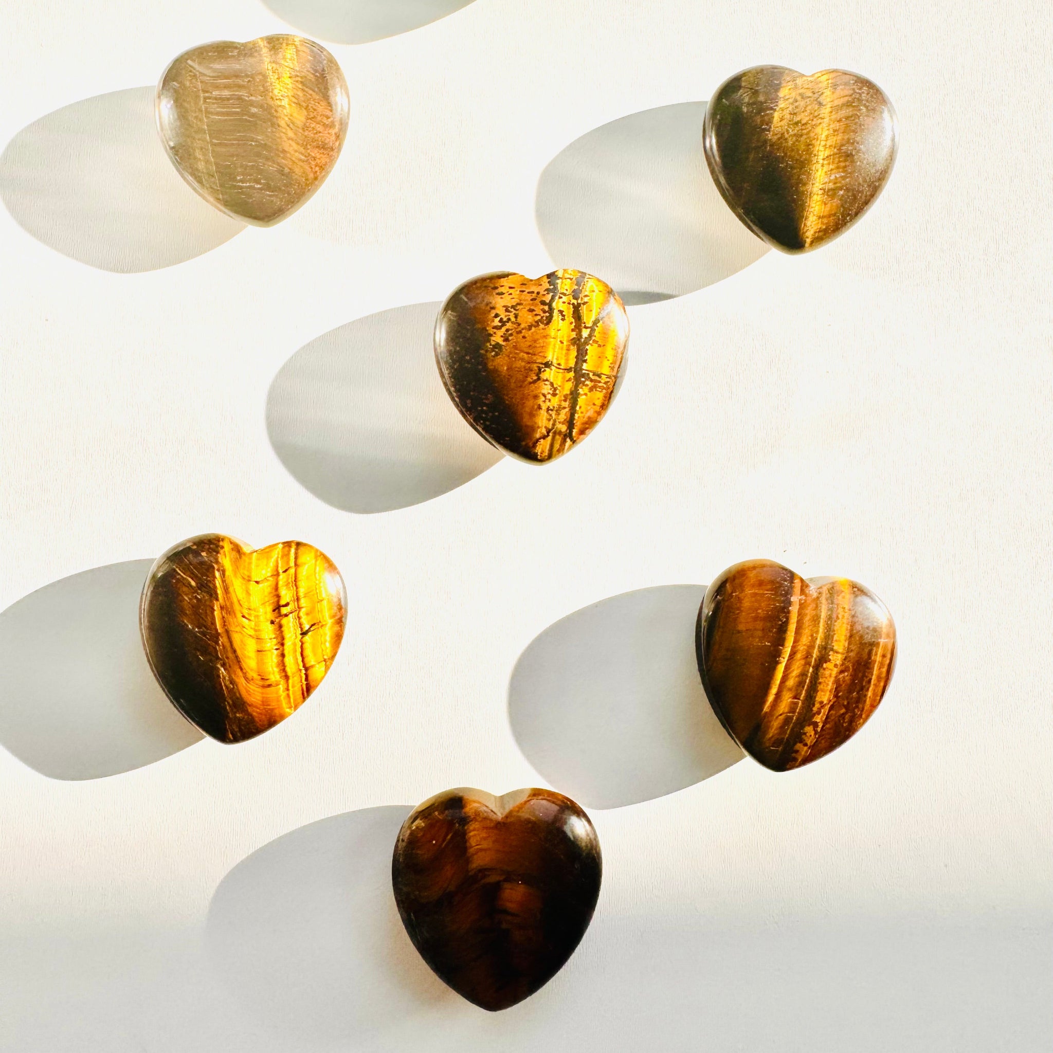 Set of heart-shaped objects with gold and brown finishes on a white background