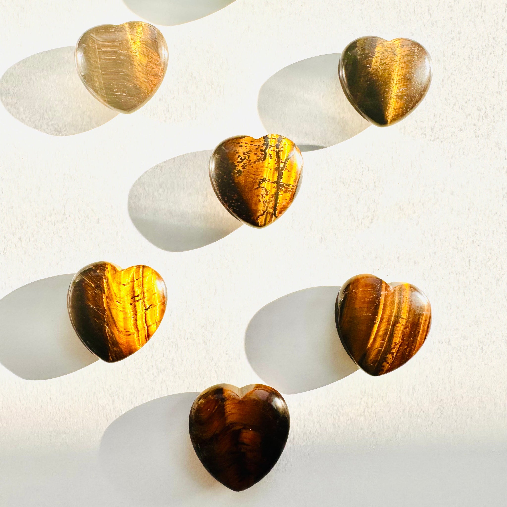 Set of heart-shaped objects with gold and brown finishes on a white background