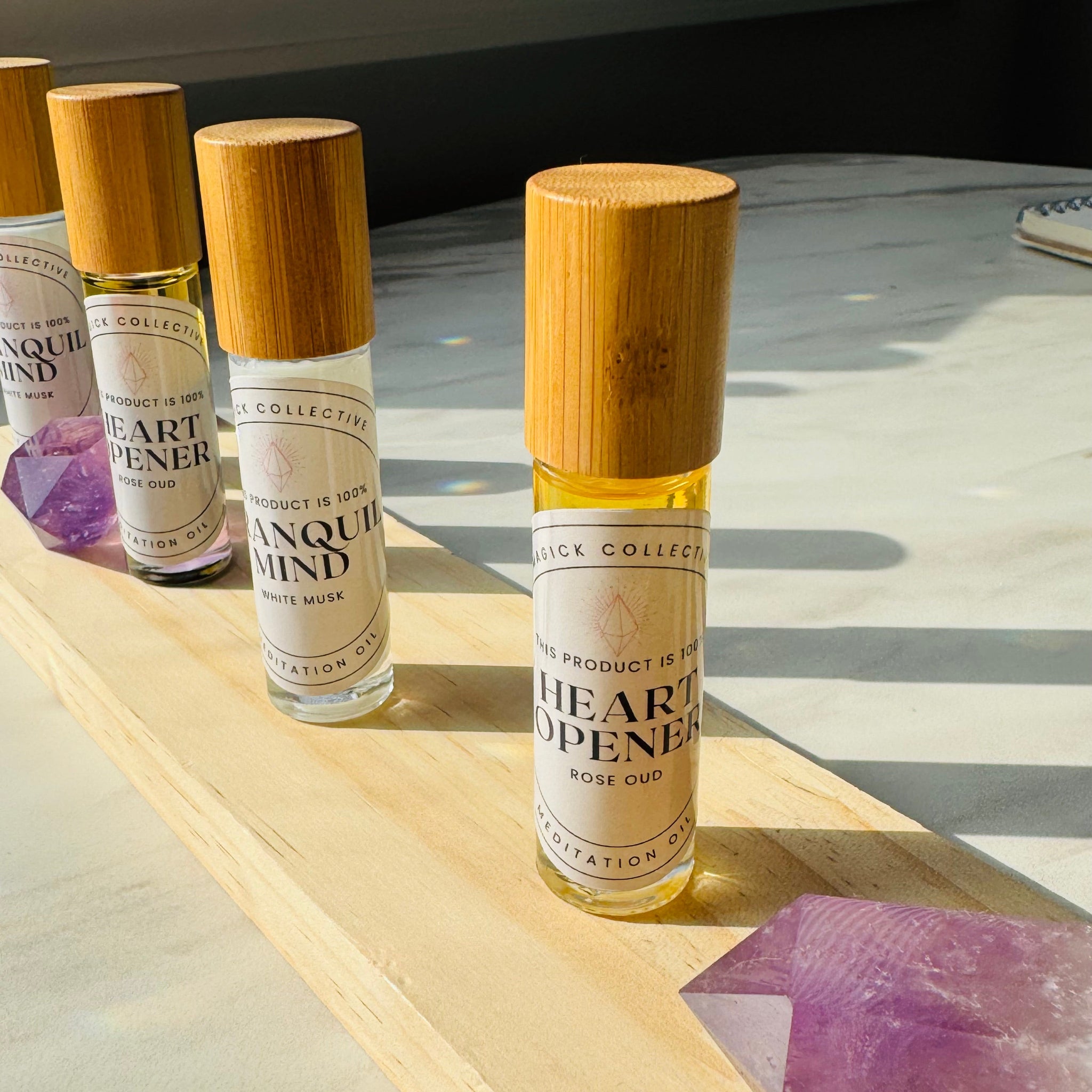 Tranquil Mind and Heart Opener Oils on wooden surface with amethyst
