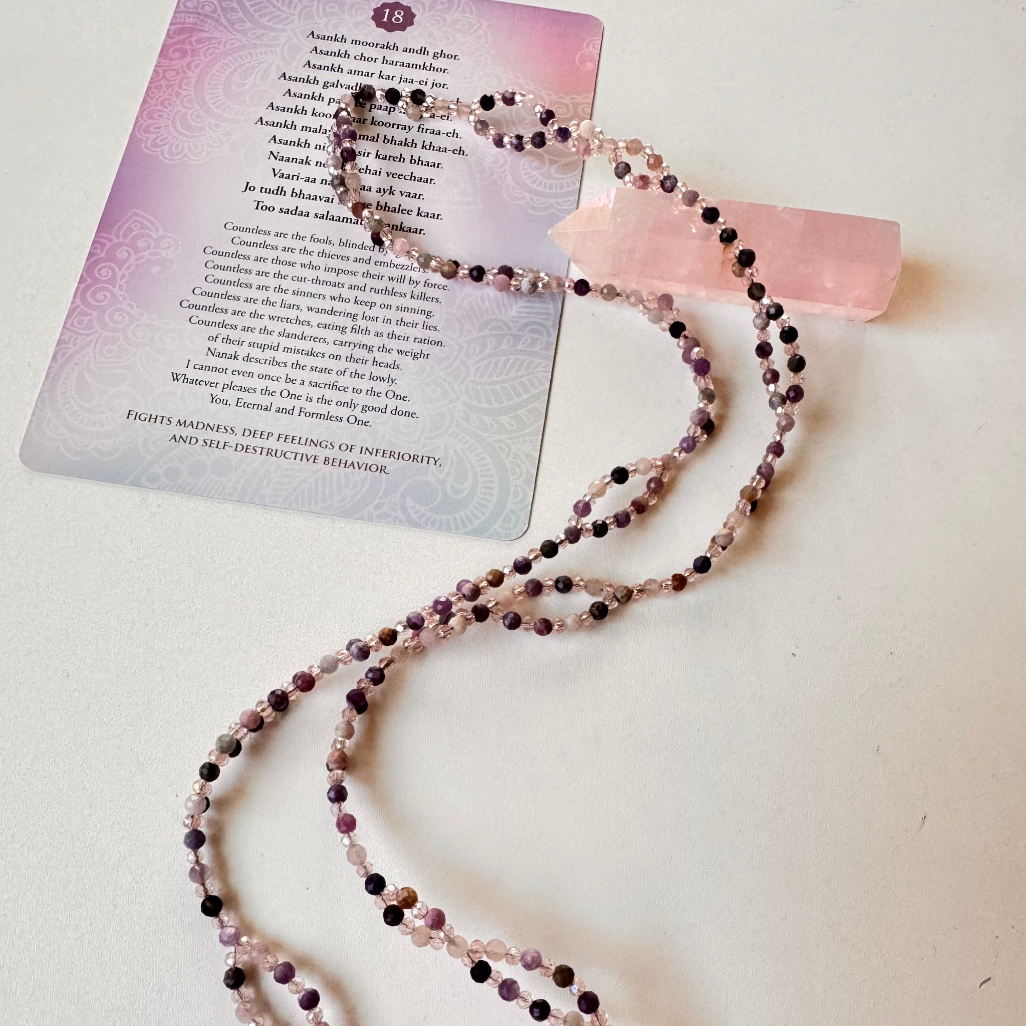 Lepidolite Tantric Necklace with mantra card and pink crystal on white surface