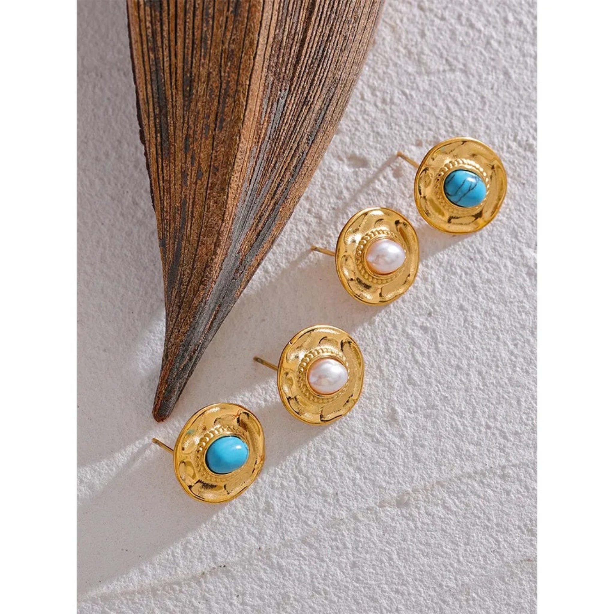 Pearl and Turquoise stud earrings on surface