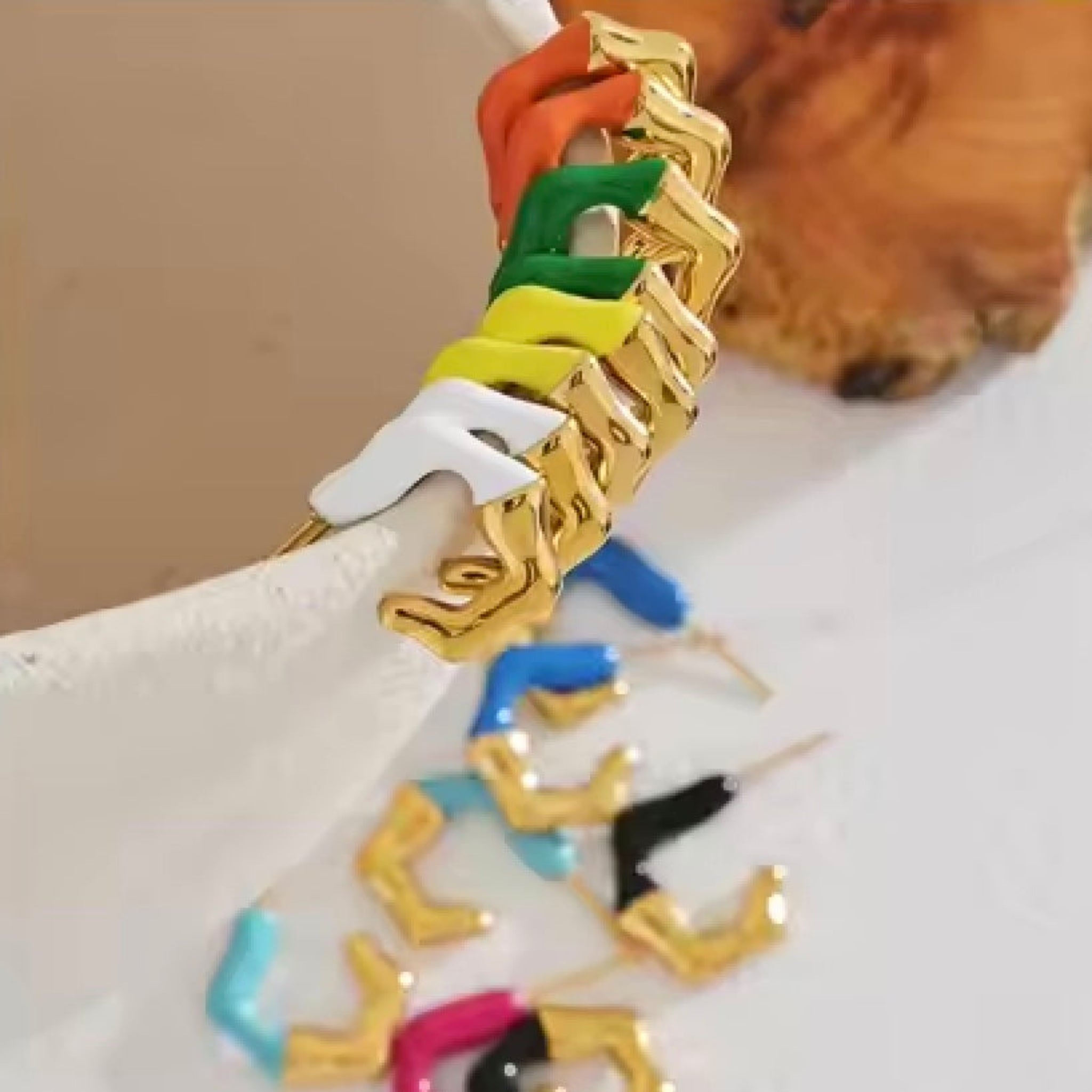 Colorful earrings on a white surface with a wooden background.