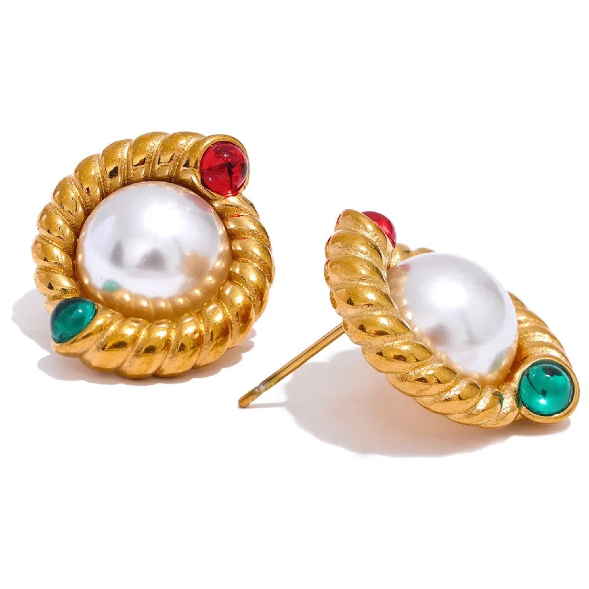 A pair of vintage pearl stud earrings with gold accents and red and green details on a textured background.