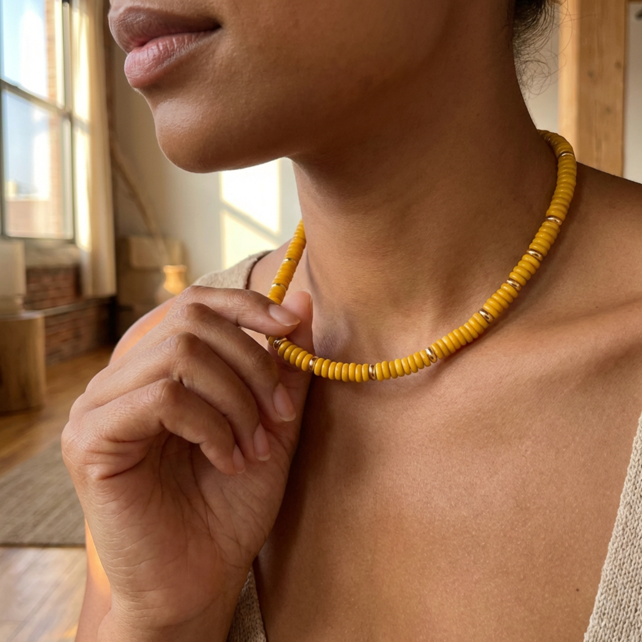 Person wearing a yellow beaded necklace indoors