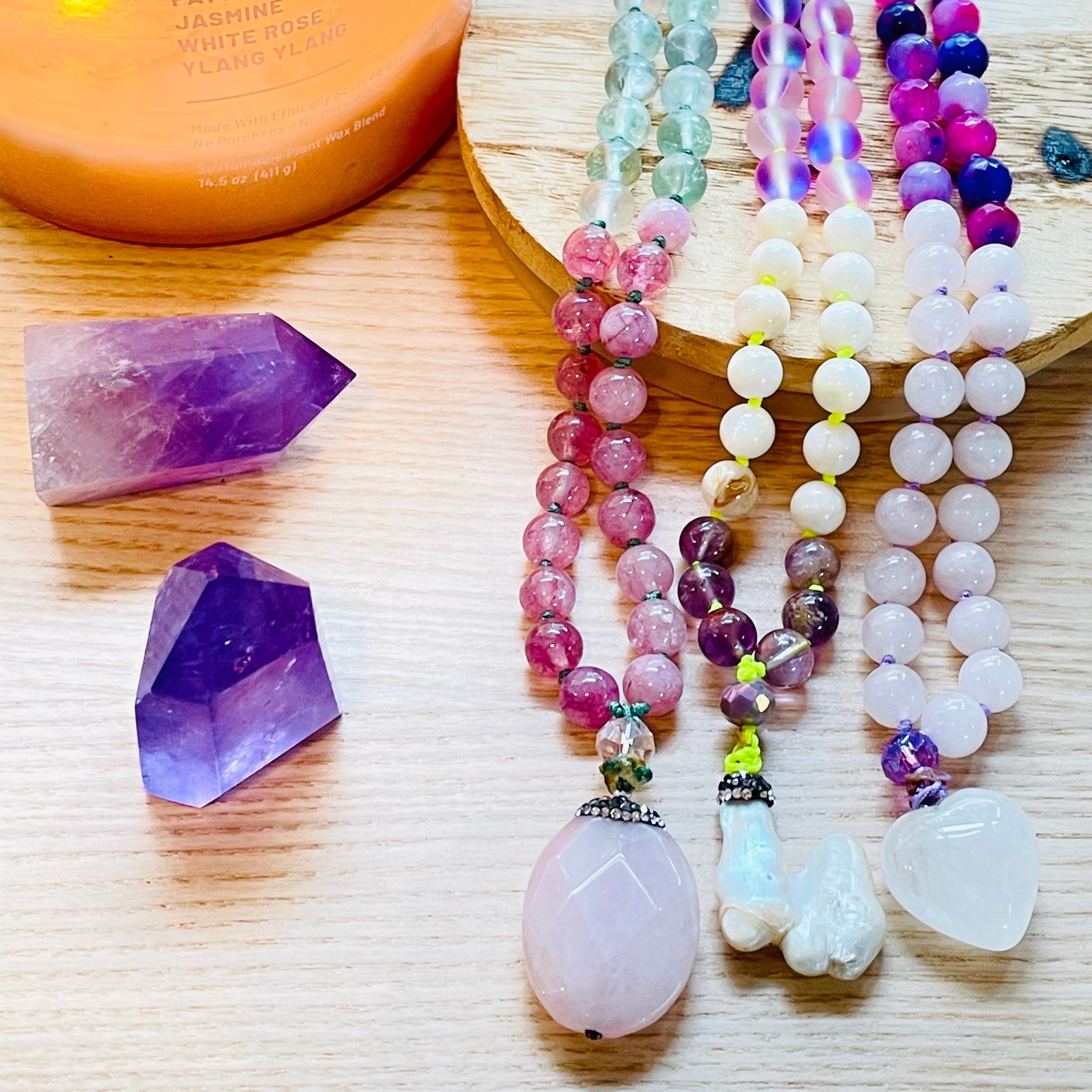 colorful beads with purple gemstone on wood surface