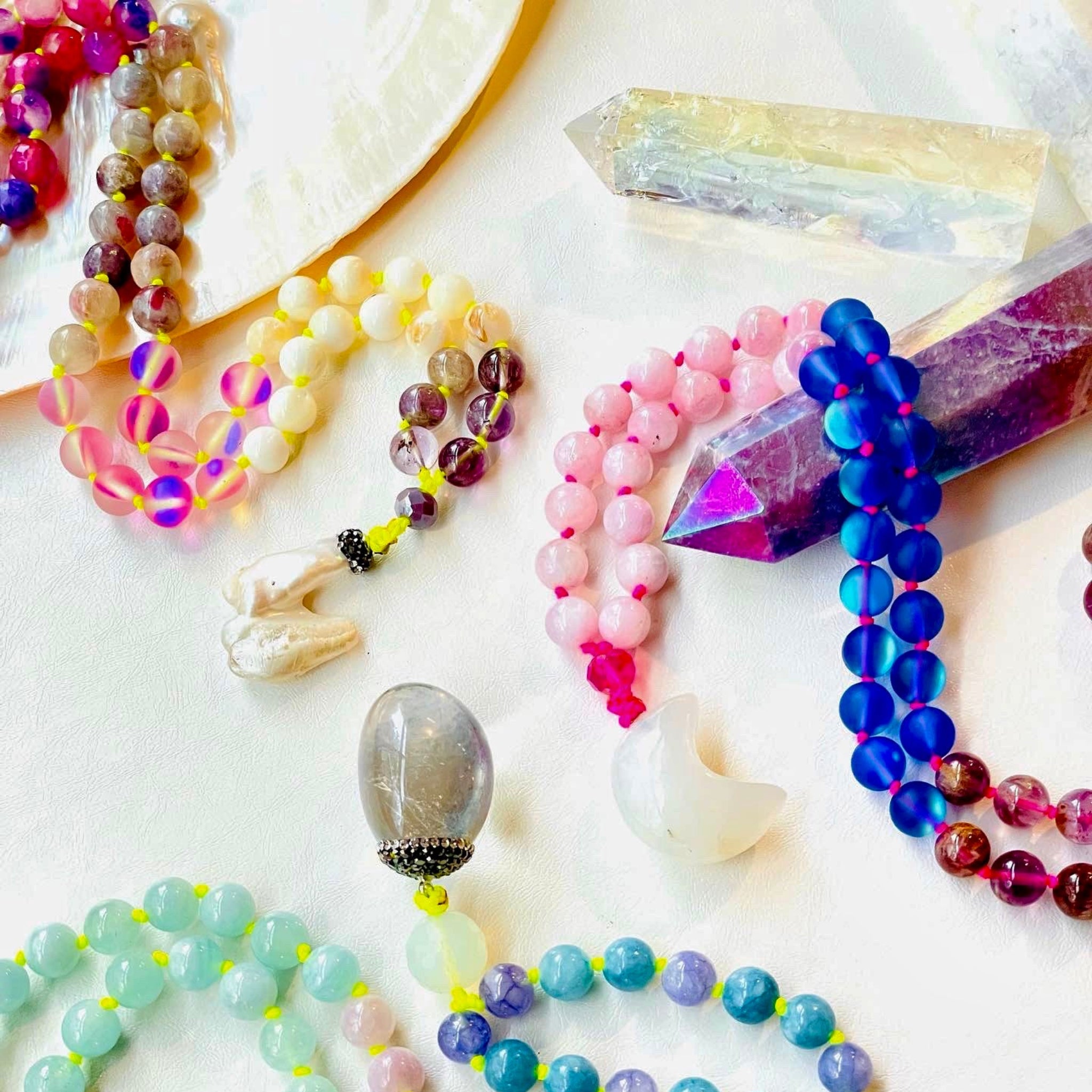 colorful necklaces with crystals on white surface