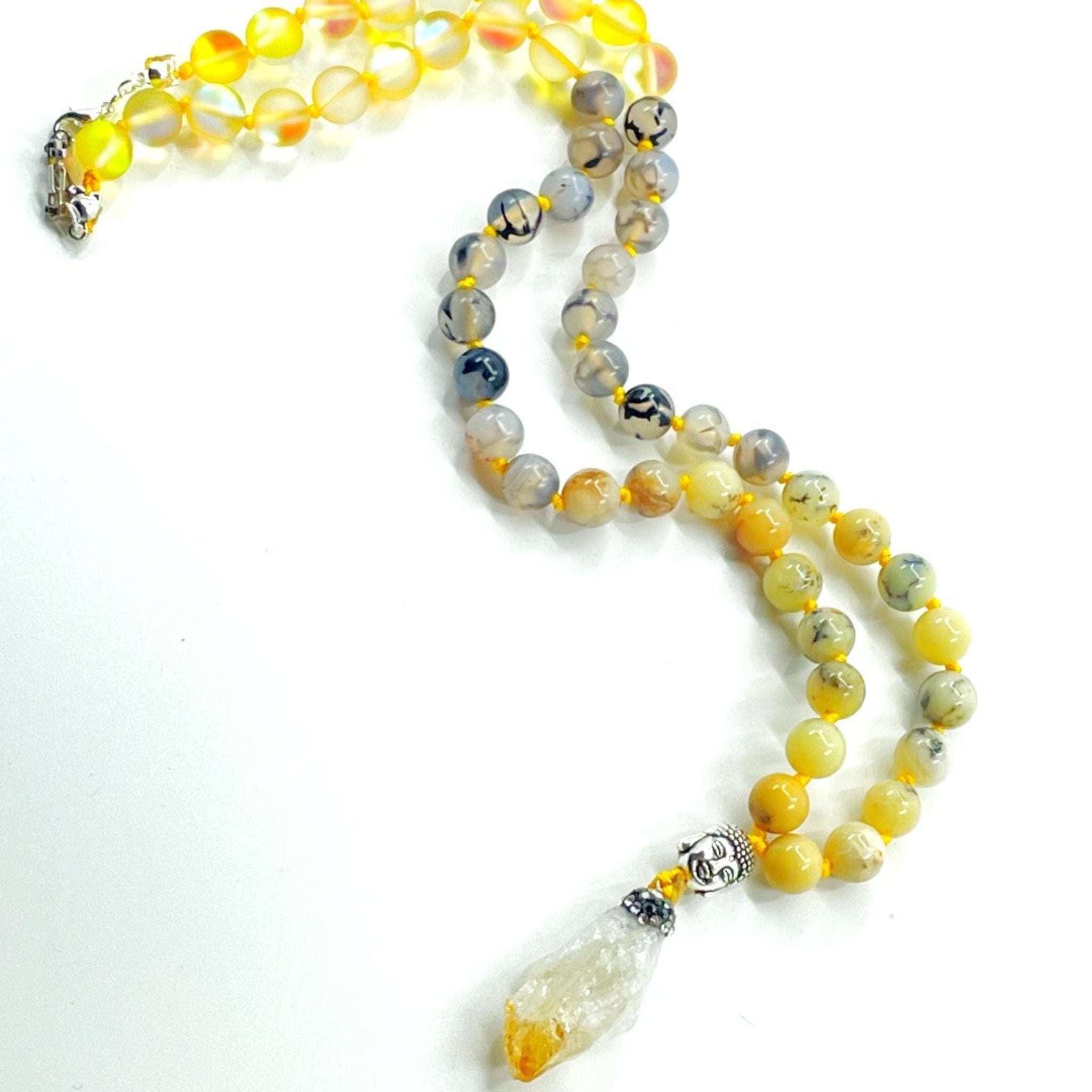 A colorful half mala necklace with yellow and clear gemstone beads, a citrine pendant, and a yellow opal bead.
