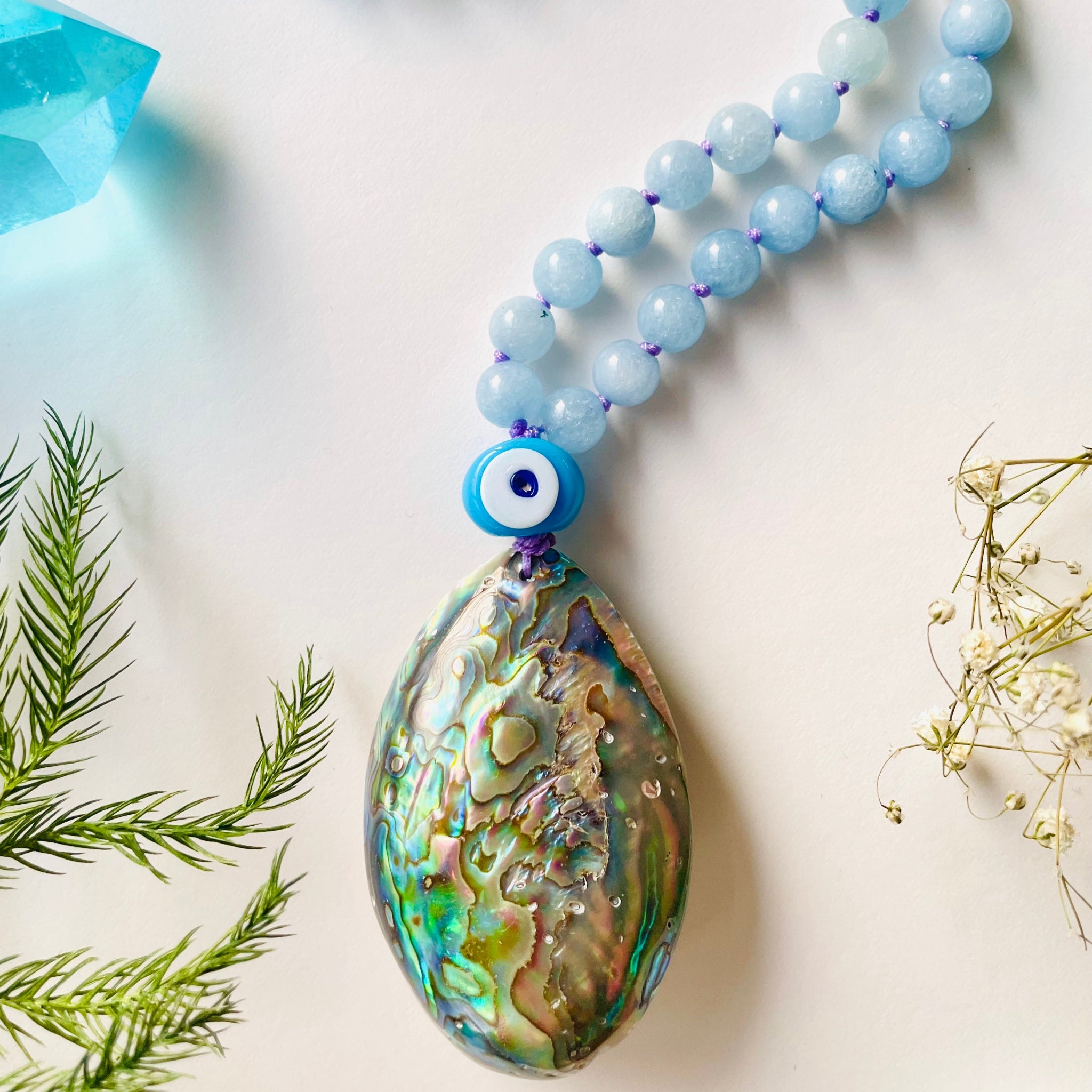 closeup image of shell pendant with evil eye