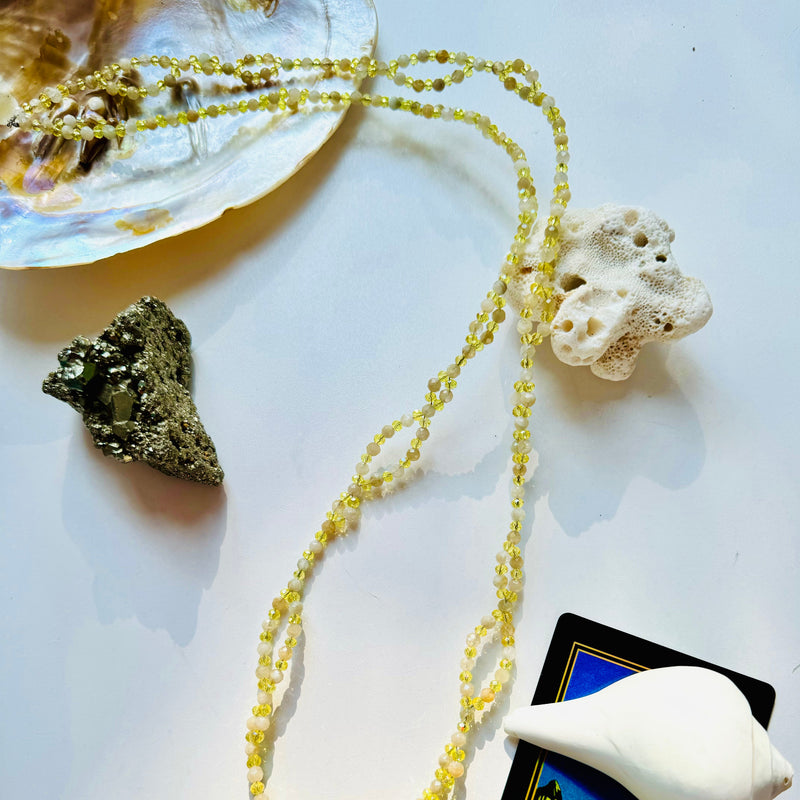 closeup photo of citrine tantric necklace with decorative crystal and seashells