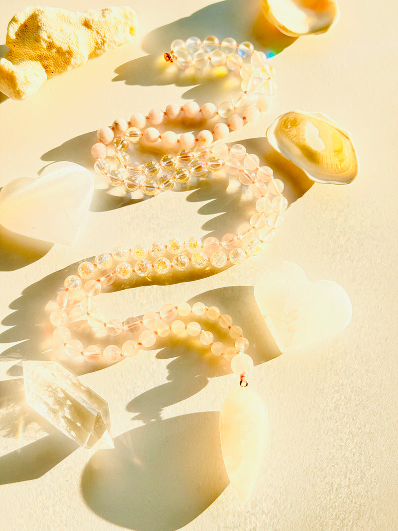 Clear bead necklaces on a light beige surface with soft shadows