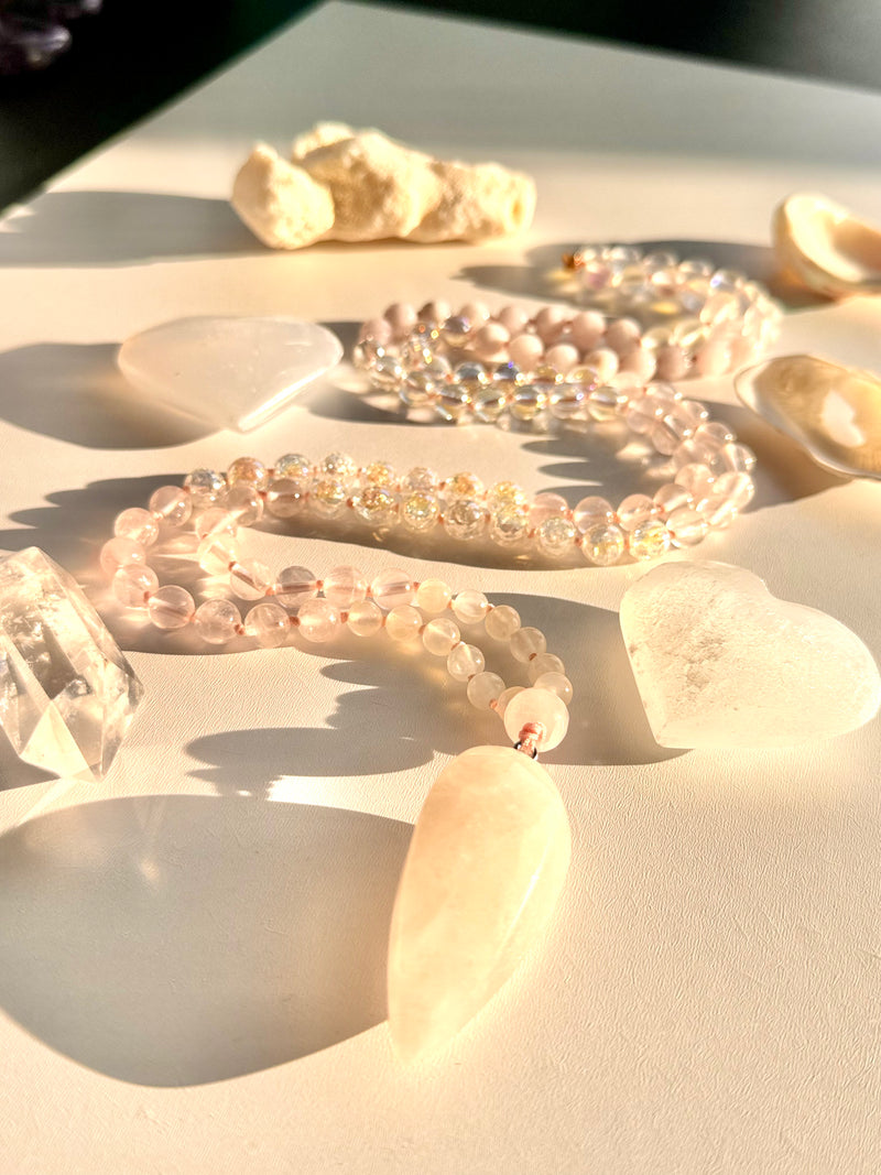 Clear Bead necklaces on a sandy surface with seashells