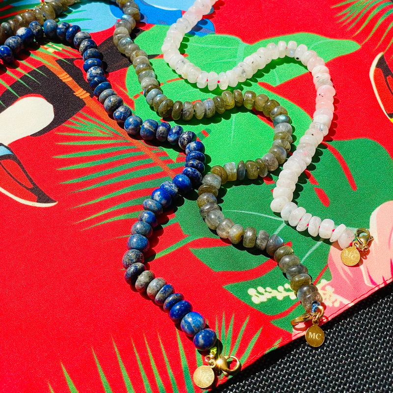 Assorted beaded colorful necklaces on colorful patterned surface