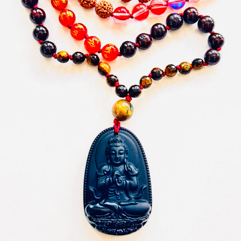 Necklace with multicolored beads and a black Buddha pendant on a white background