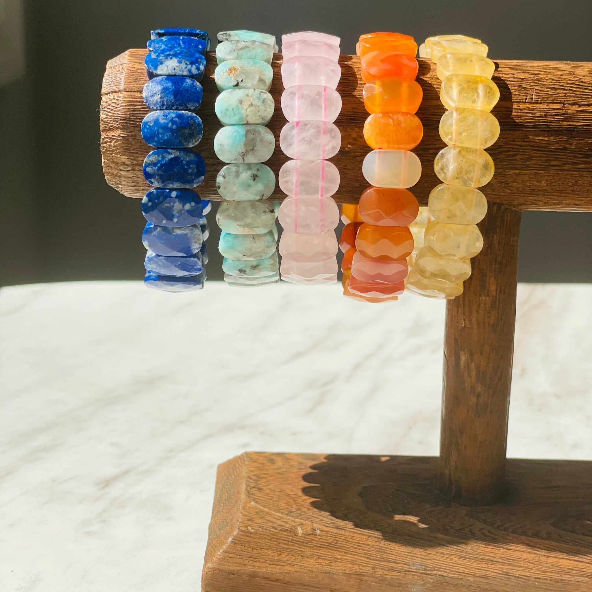 Colorful gemstone bracelets on wooden display