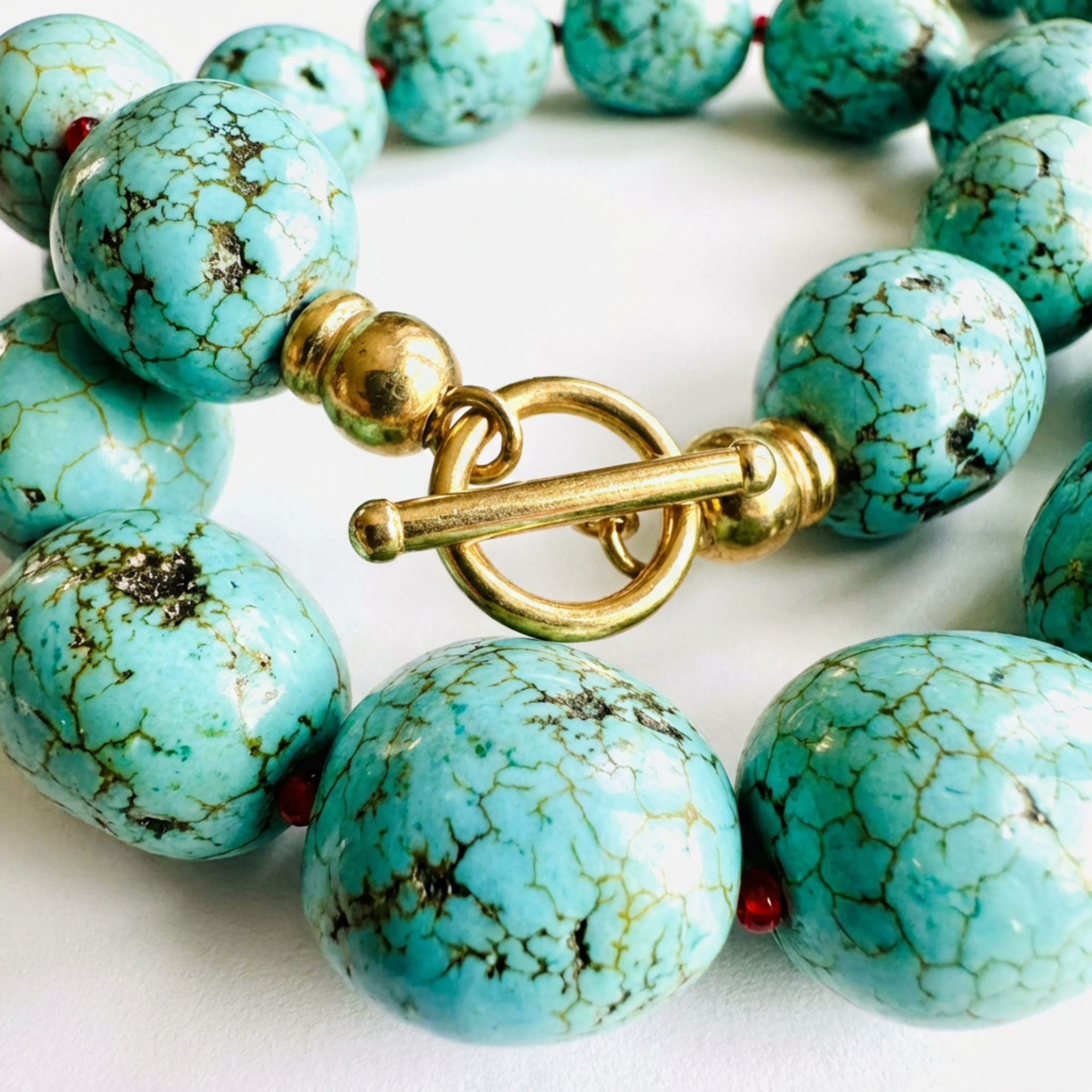Turquoise beaded bracelet with a gold clasp on a white background