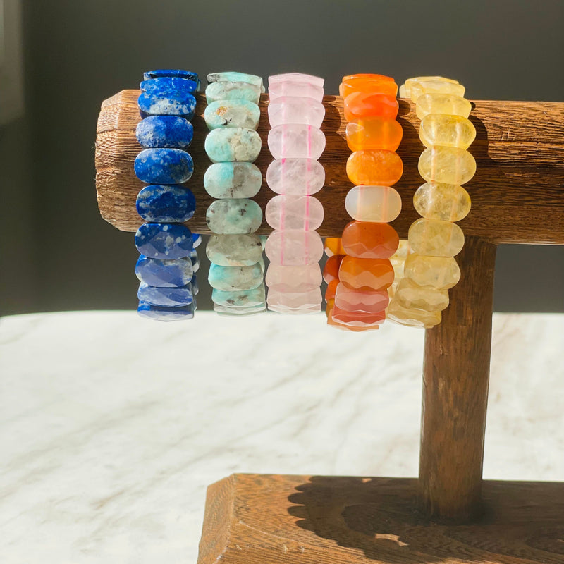 colorful gemstone bracelets on wooden display