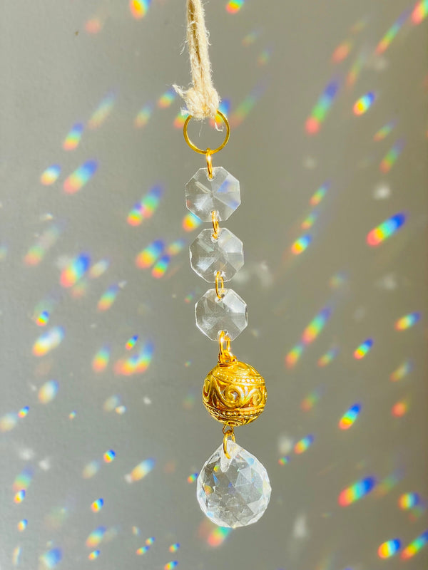 Clear ball hanging ornament in front of white surface