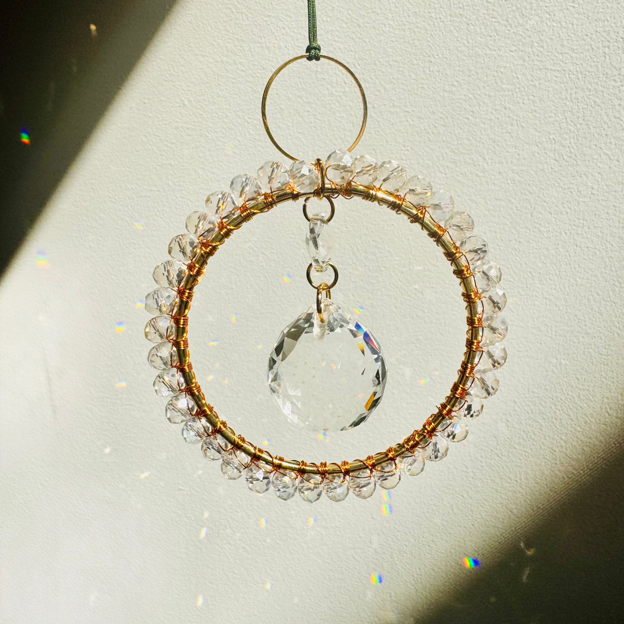 Crystal hanging ornament with beaded design on a plain background