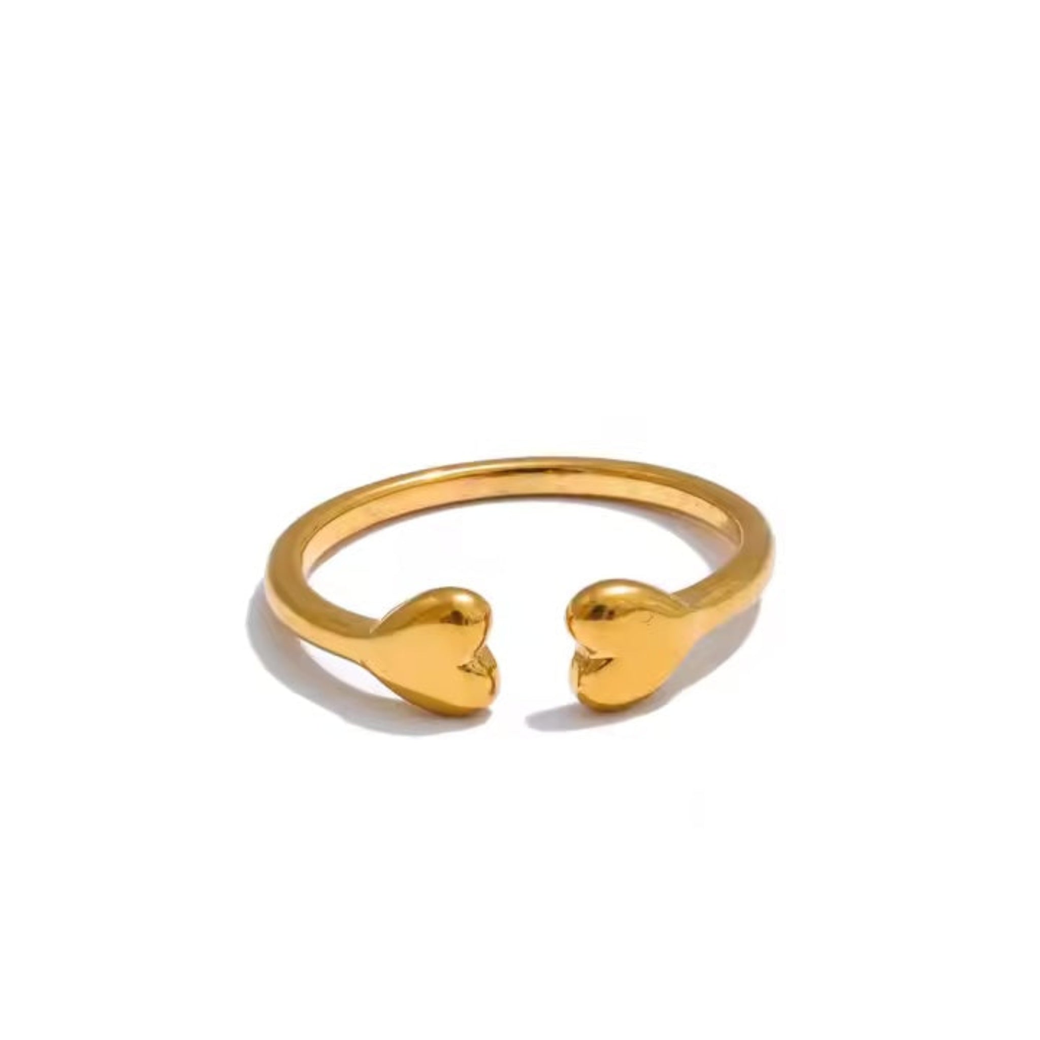 A gold-colored open band ring with two petite heart details on the top, placed against a white background.