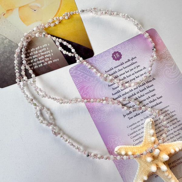 Kunzite Tantric Necklace on white surface with star and mantra cards
