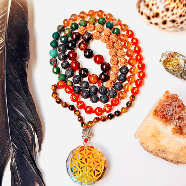 Colorful beaded necklace with a yellow pendant on a white surface with a feather and shell.