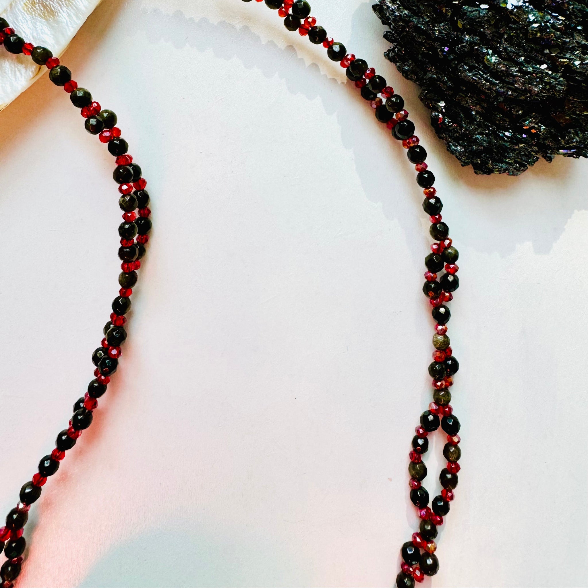 black and red gemstone tantric necklace closeup photo with black crystal as decor