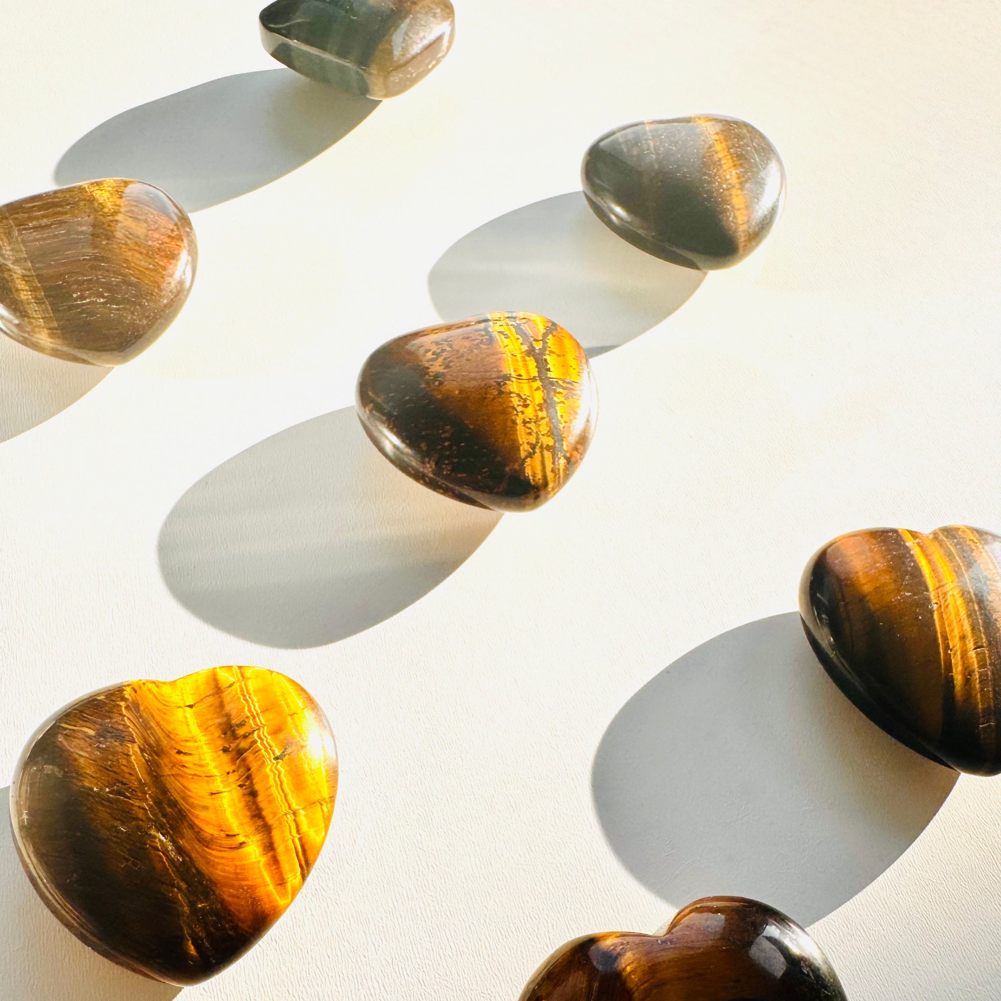 Heart-shaped tiger's eye stones on a light background