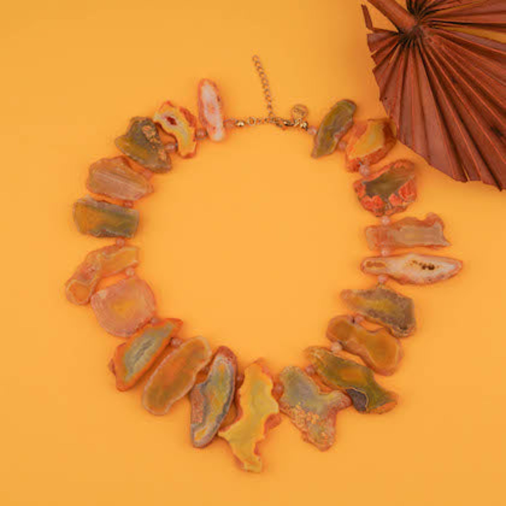 Slab cut honey agate necklace on yellow surface