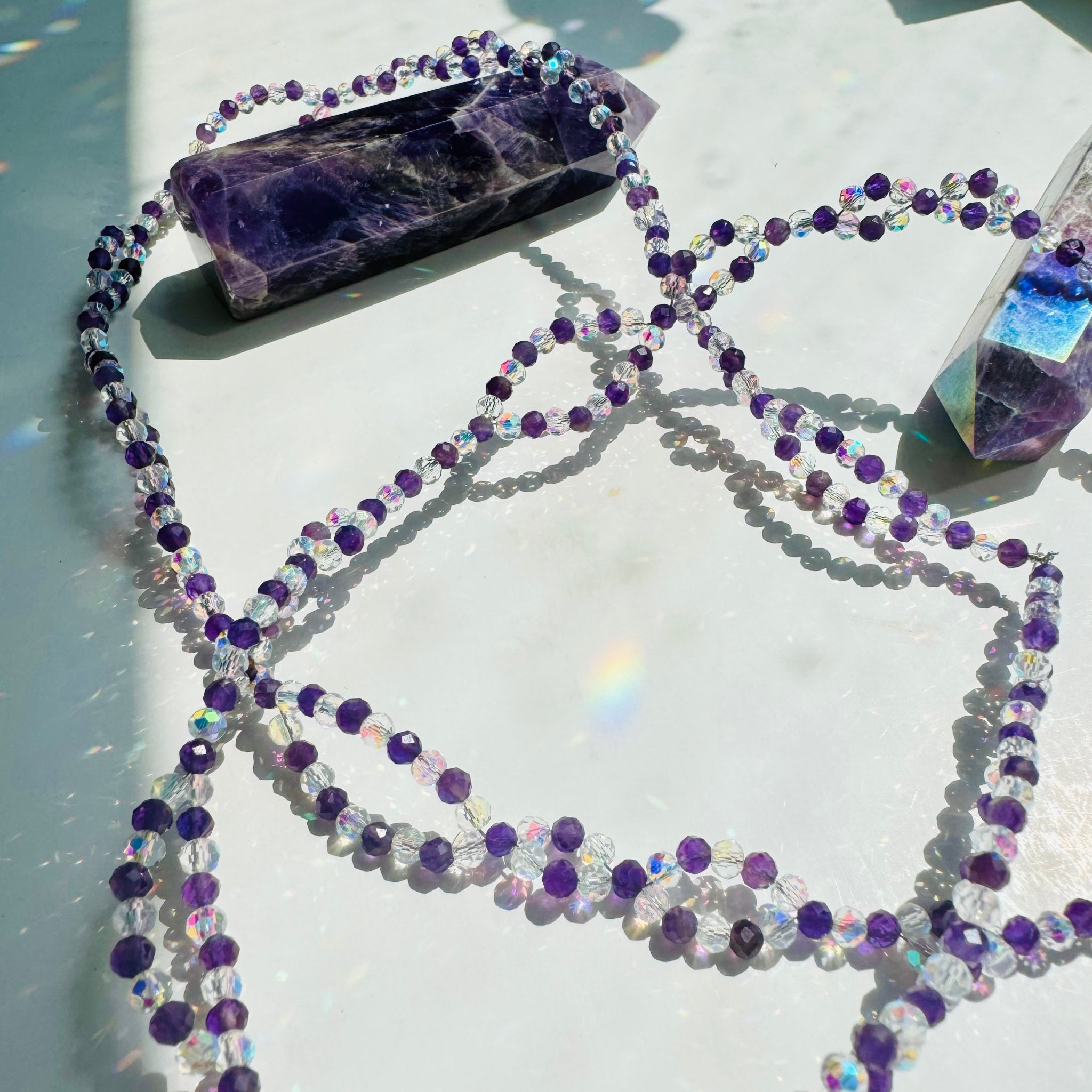 Inner Peace Amethyst Tantric Necklace
on white surface and purple decorative crystals