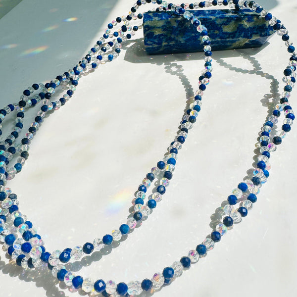 Lapis Lazuli tantric necklace on white surface and lapis lazuli tower crystal